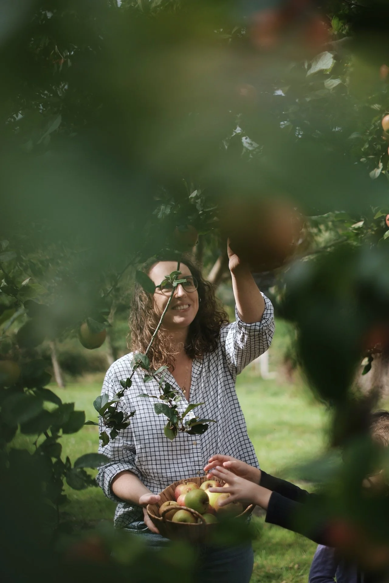 Deux participantes souriantes cueillant des pommes dans la pommeraie du domaine — parenthèse de vie simple et joyeuse lors d'une retraite yoga nature en France