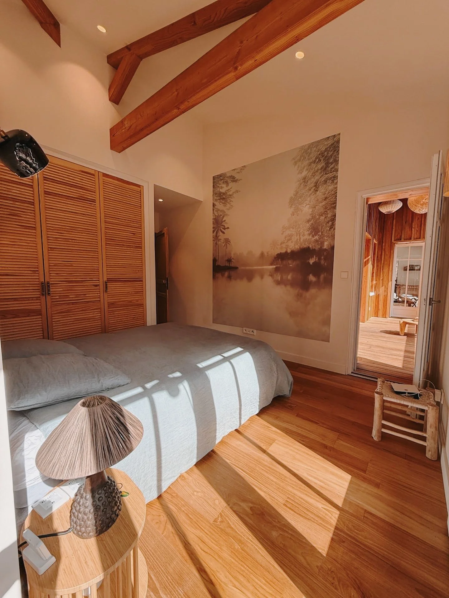 Chambre privative au parquet chaleureux et dressing en bois clair, lumière douce du matin — intimité d'une retraite yoga Sud-Ouest