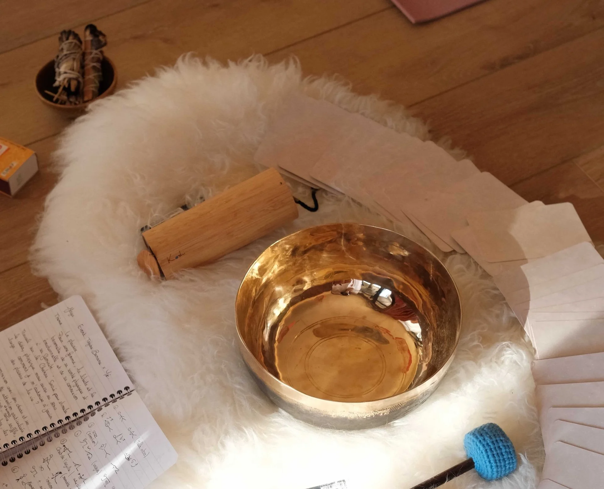 Bol tibétain et palo santo posés sur peau de mouton, atelier womb healing retraite féminine Lacanau