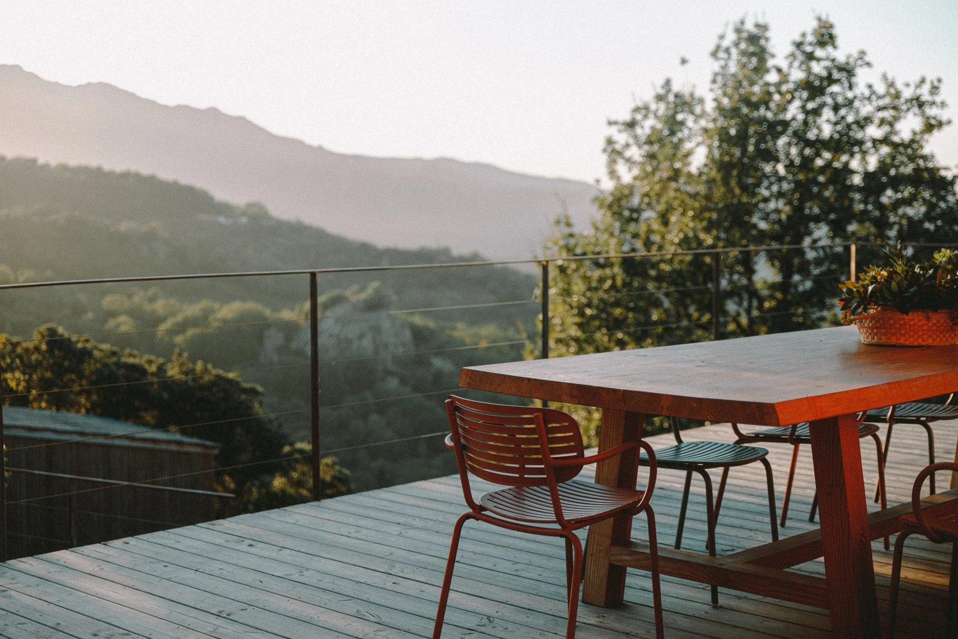 Terrasse paisible baignée de lumière dorée en Haute-Corse. Un espace parfait pour méditer, lire ou se reconnecter à soi pendant une retraite de yoga et développement personnel.