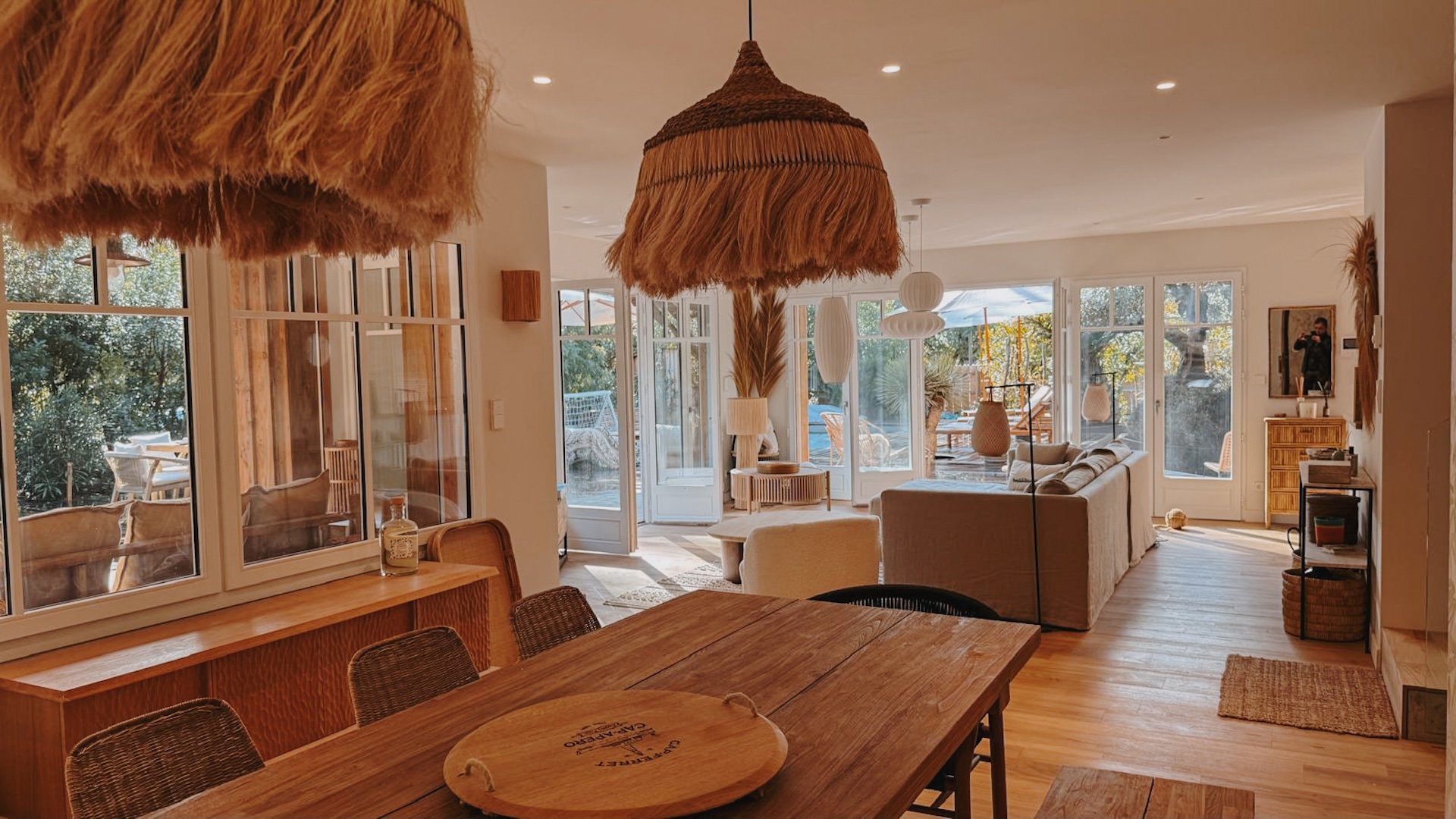 Salle à manger chaleureuse avec table ronde en bois et suspension en raphia — cuisine végétarienne locale d'une retraite yoga Sud-Ouest