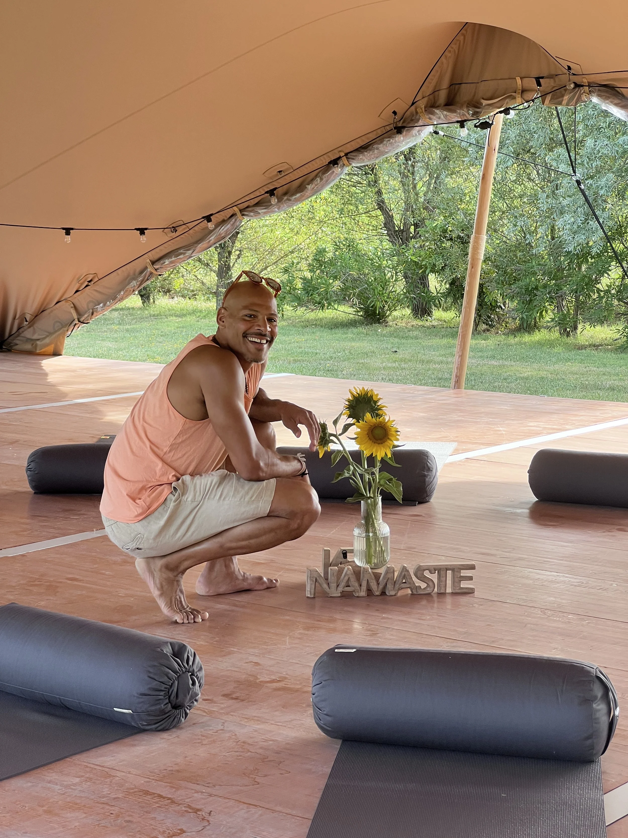 Pema au centre de la salle de yoga, guidant une pratique fluide et consciente dans un espace lumineux dédié à la reconnexion et à la respiration