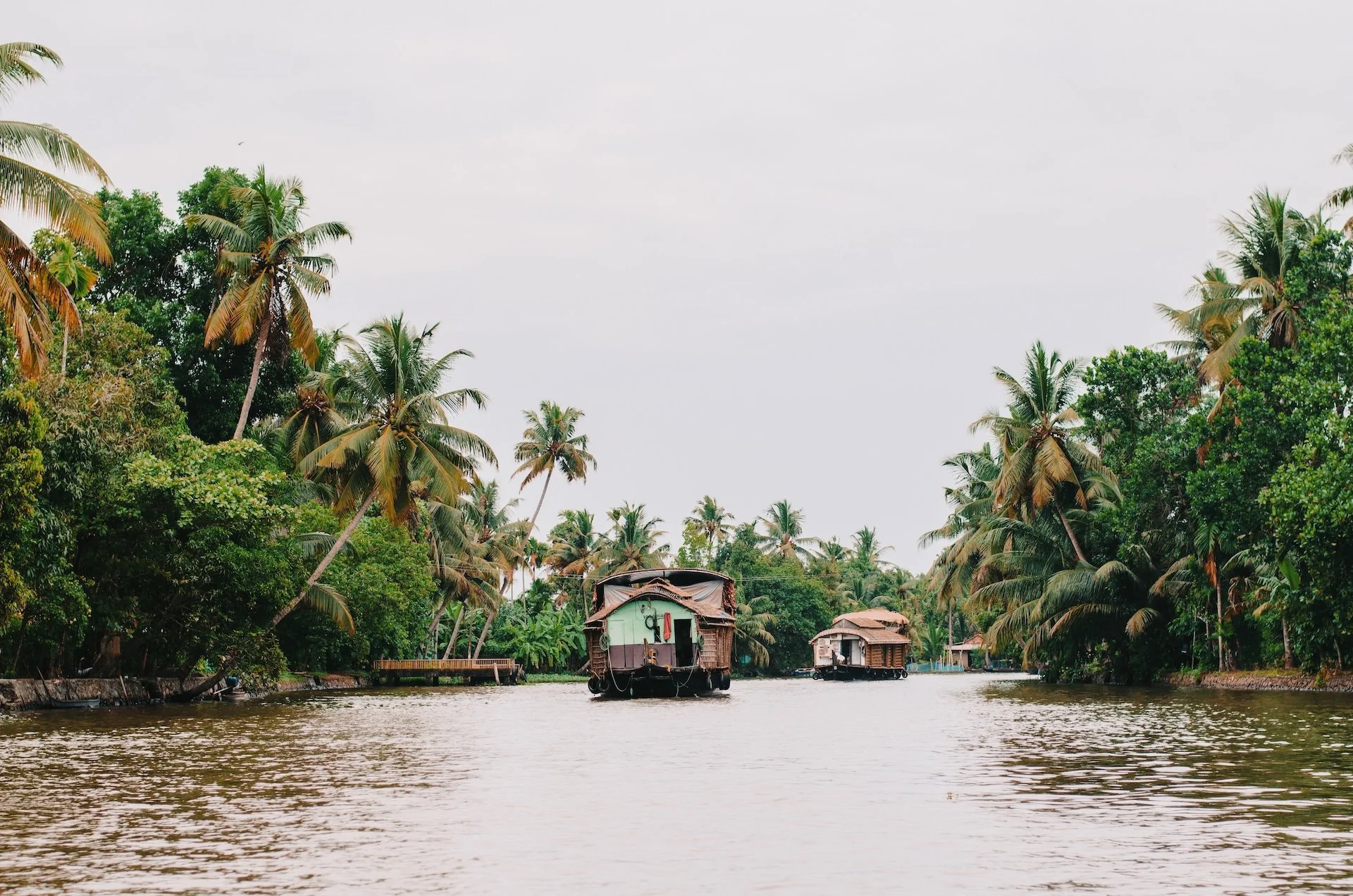 Houseboat traditionnel glissant sur les Backwaters du Kerala, entre palmiers et eaux calmes — voyage ayurvéda en Inde du Sud