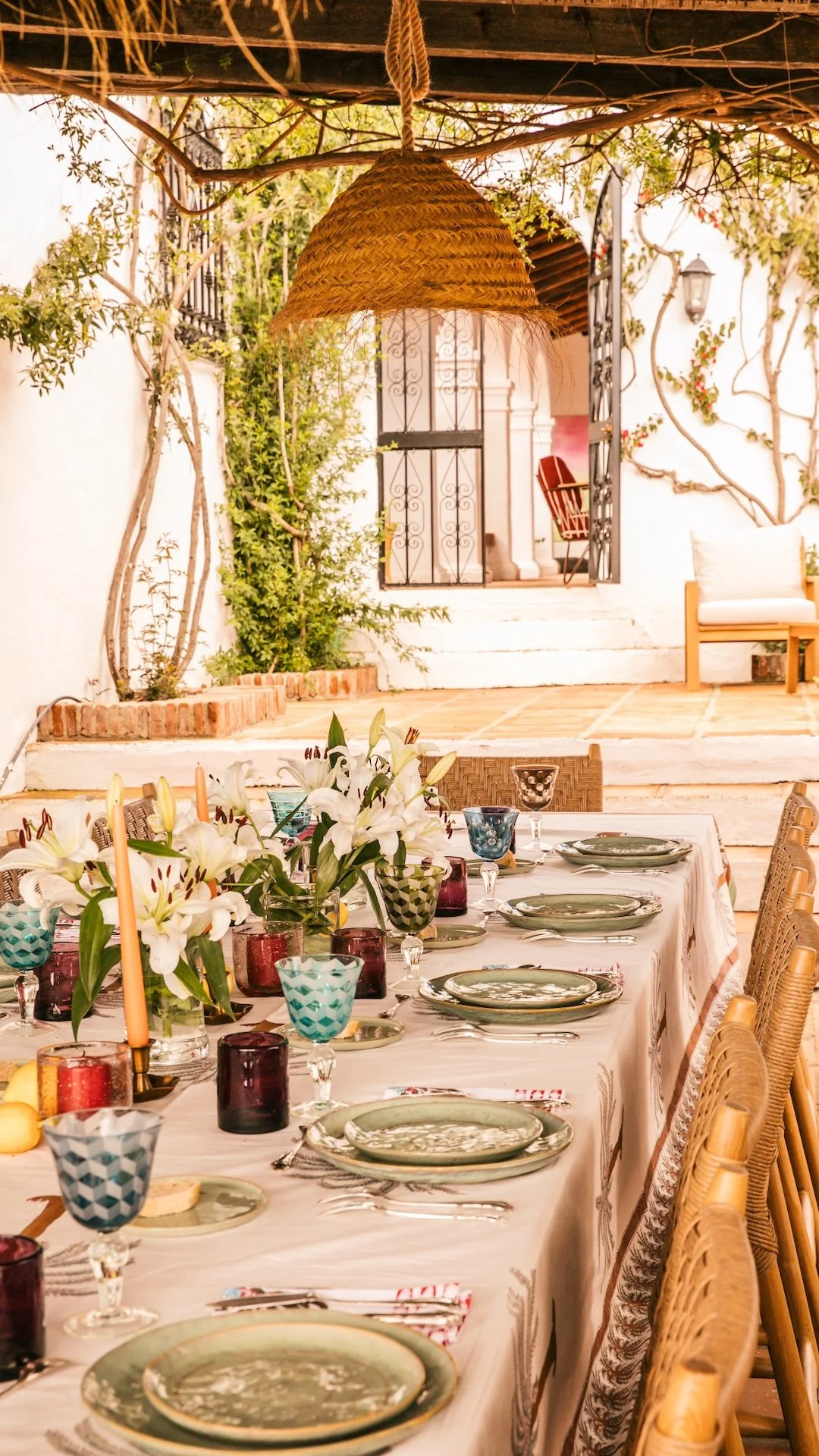 Table dressée pour un dîner en terrasse avec lys et vaisselle artisanale — pension complète retraite yoga soins Andalousie