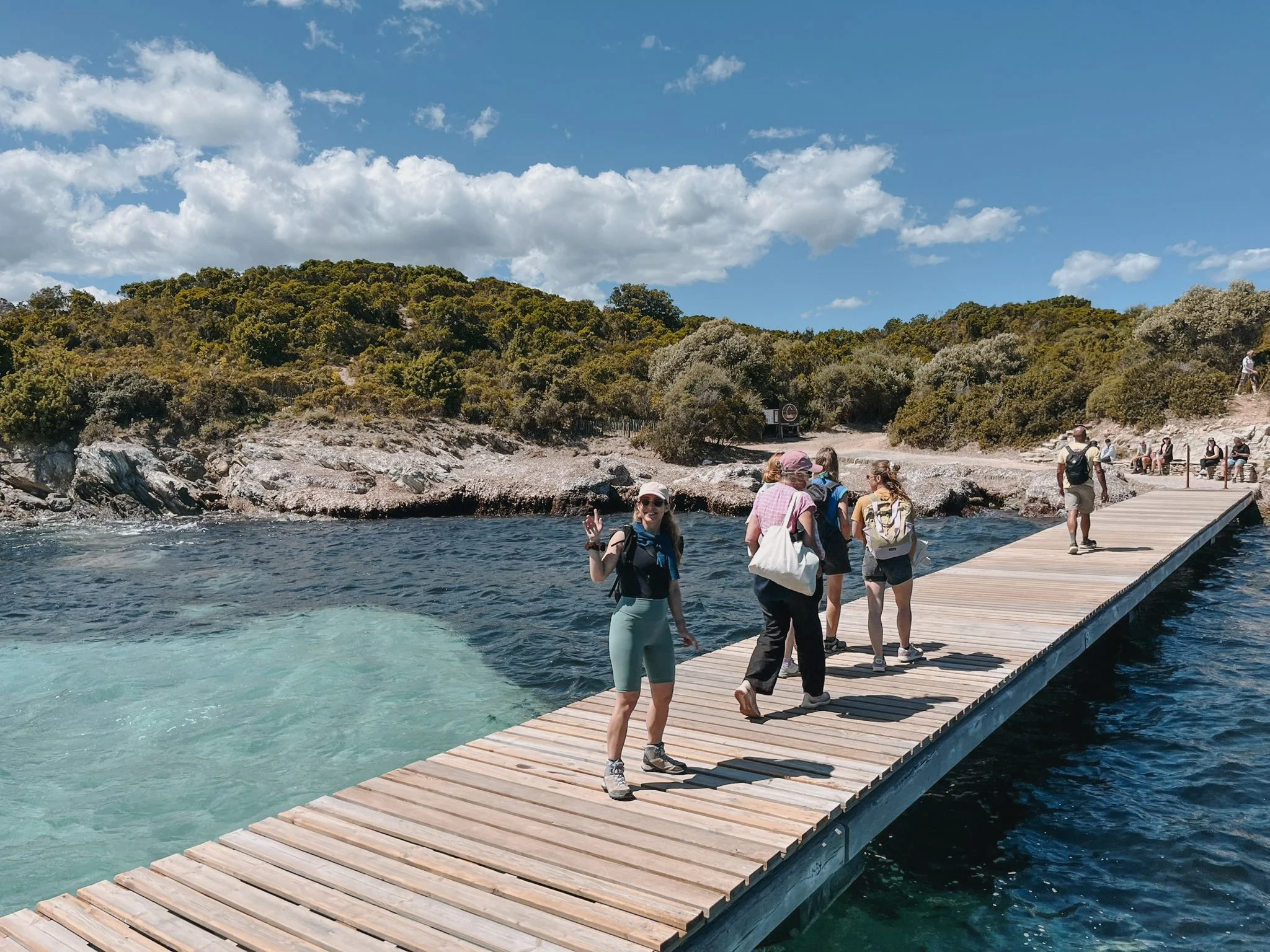 Deux femmes sur un ponton face à une crique turquoise — retraite yoga sororité Haute-Corse automne