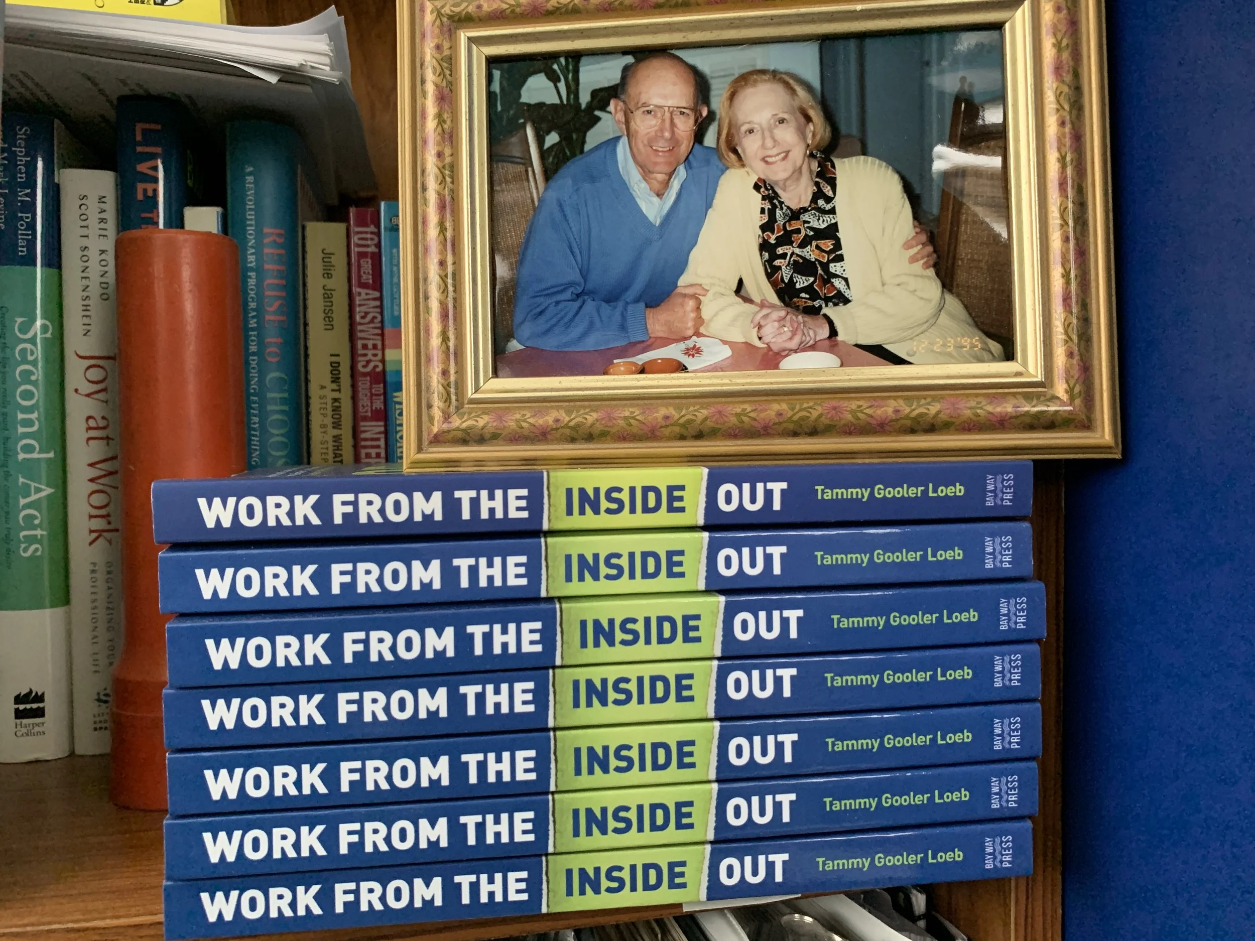 A framed photo of Tammy's parents Ed and Gloria Gooler on top of 7 Work from the Inside Out books
