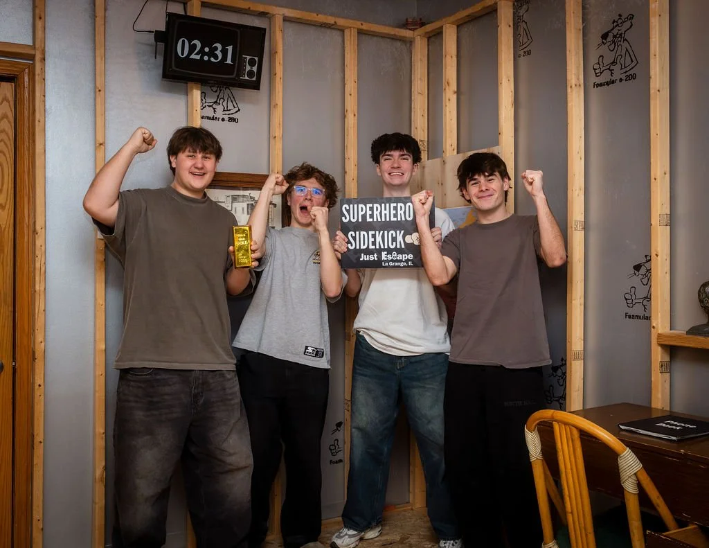 Corporate team collaborating to solve puzzles in an escape room, fostering teamwork and communication.