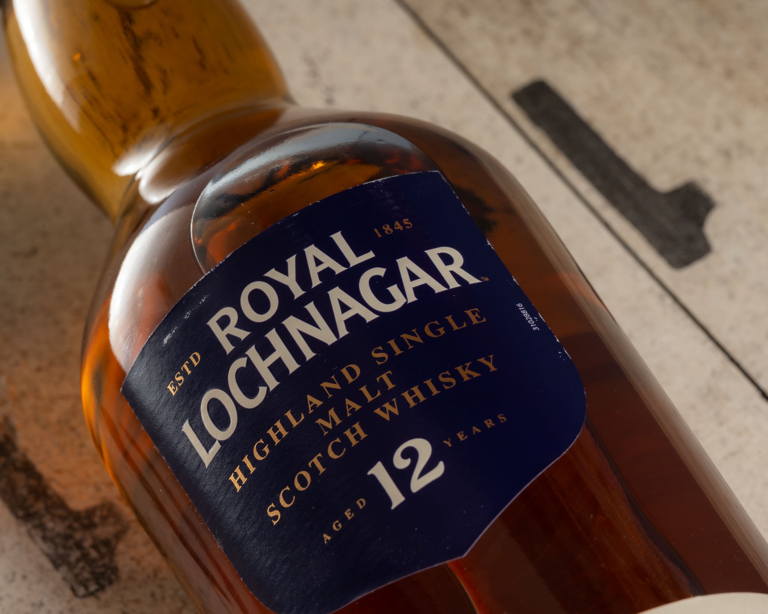 A bottle of a bottle of Royal Lochnagar 12 lying on a barrel lid