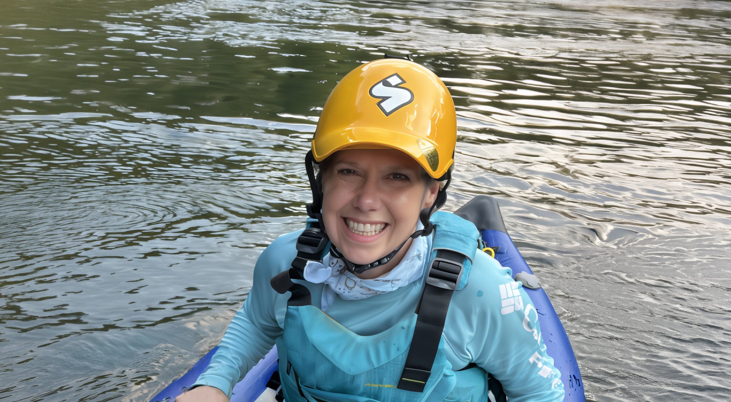Social Director Melinda Maddock in a ducky on a river.