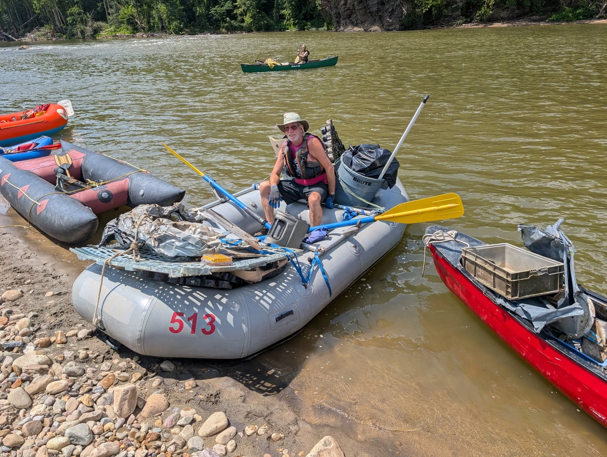 Michael Crooks, 2026 Paddler of the Year, collecting debris on the river in his raft.