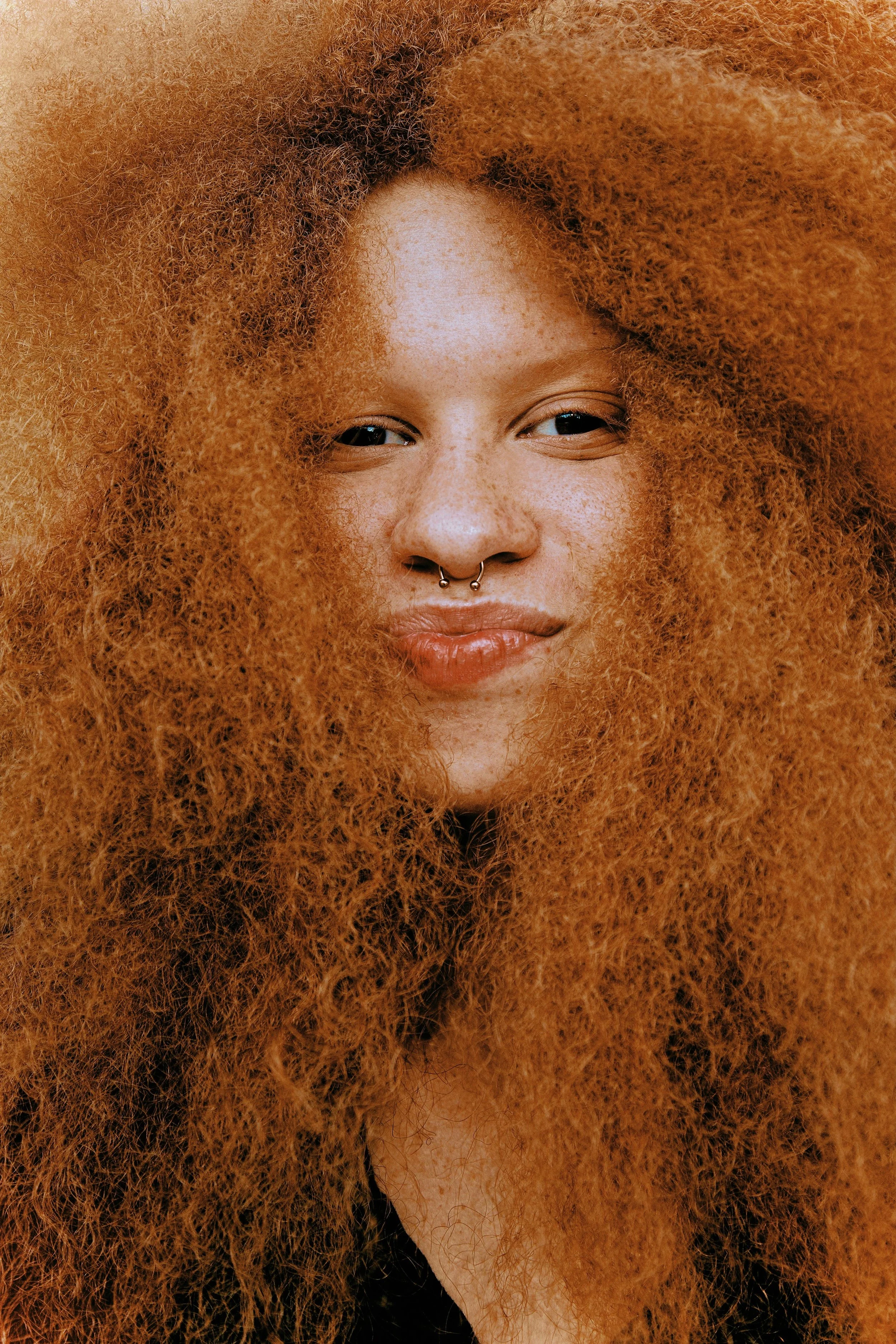 freckle faced woman smiling with kinky red hair