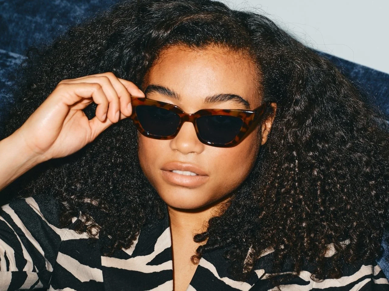 woman wearing sunglasses held up to her eyes