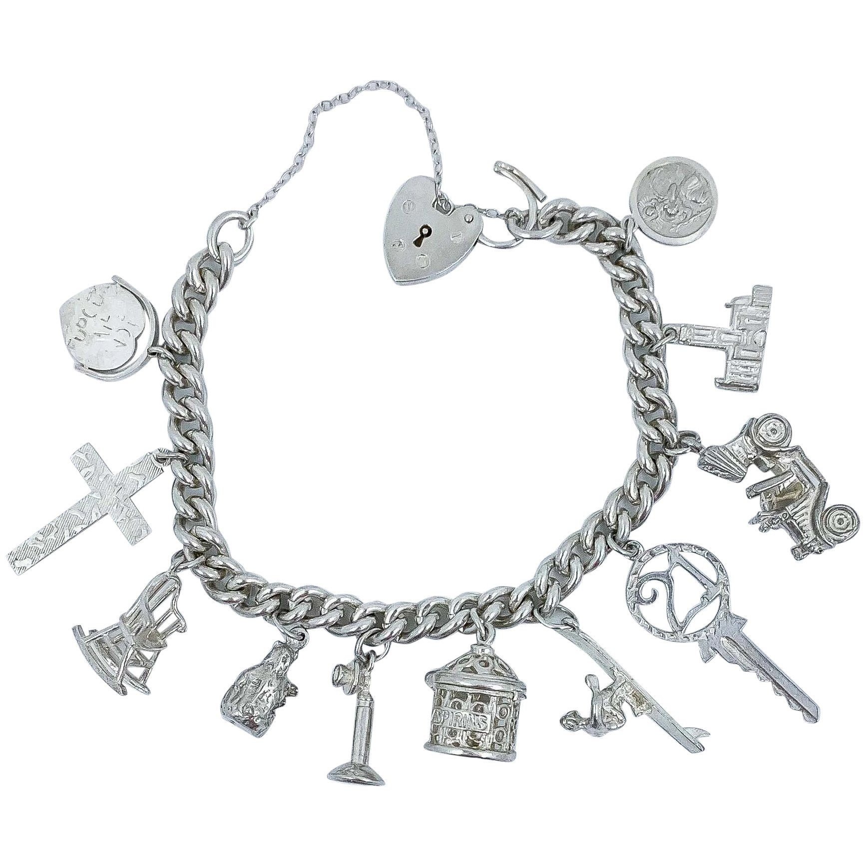 Vintage 1973 sterling silver charm bracelet with 11 charms and heart padlock, bear, car, rocking chair, surfer