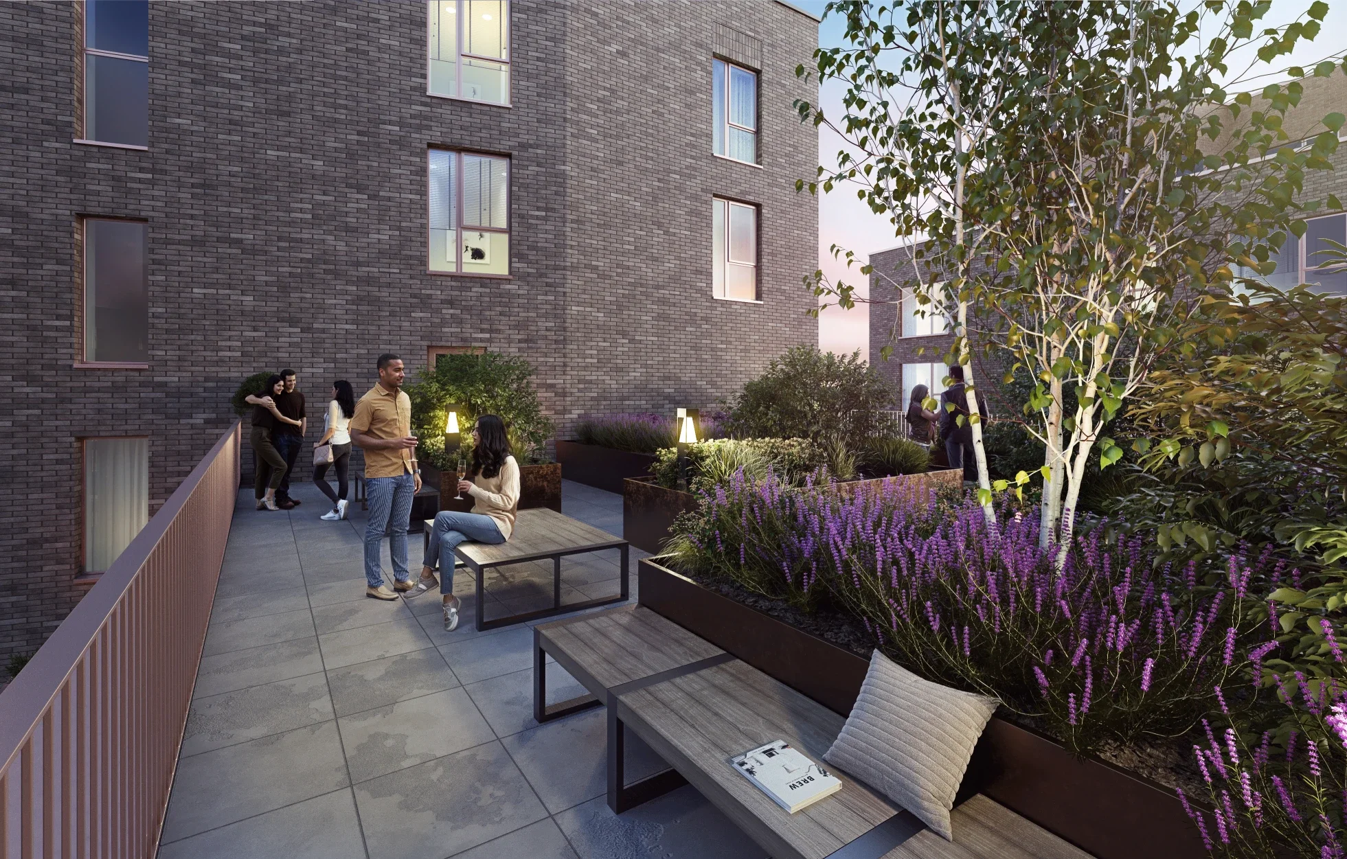 People socializing on a rooftop garden with purple flowers and modern seating, surrounded by tall brick buildings.