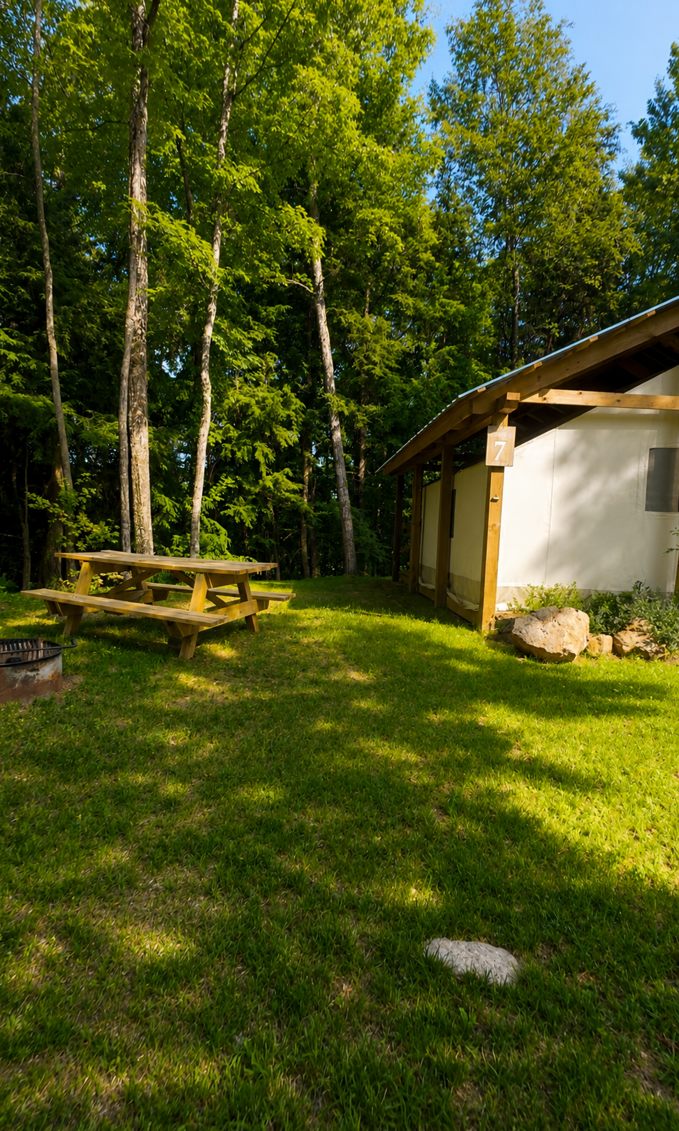 Safari-style glamping tent nestled among the trees at Raging River Resort in Michigan's Upper Peninsula.