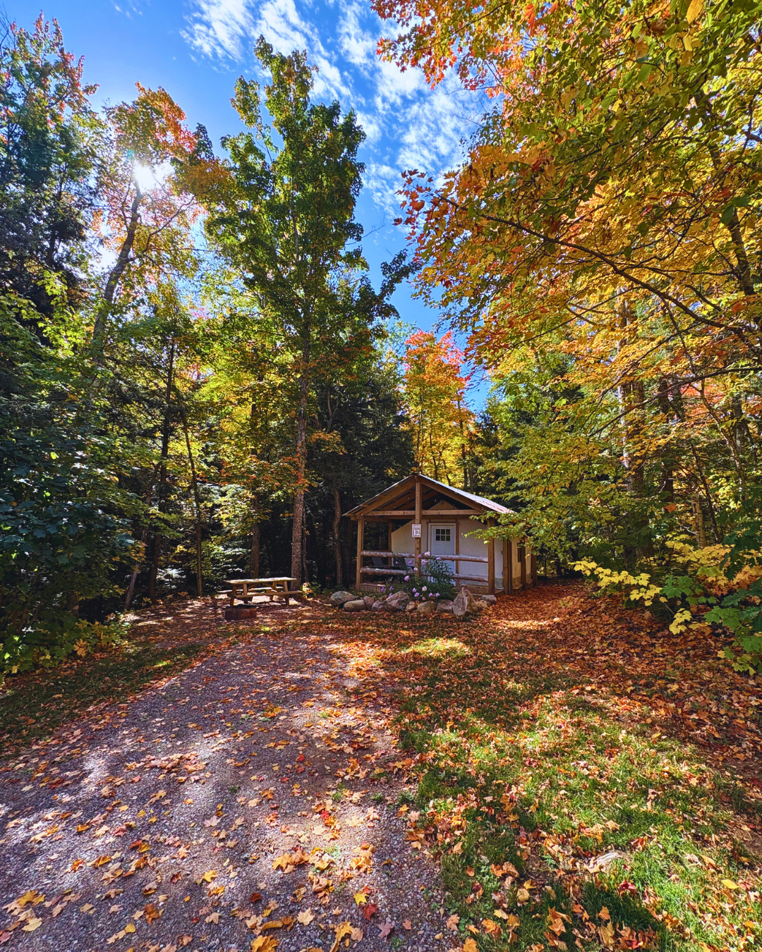 Glamping tent surrounded by colorful fall foliage at Raging River Resort in Marquette, Michigan