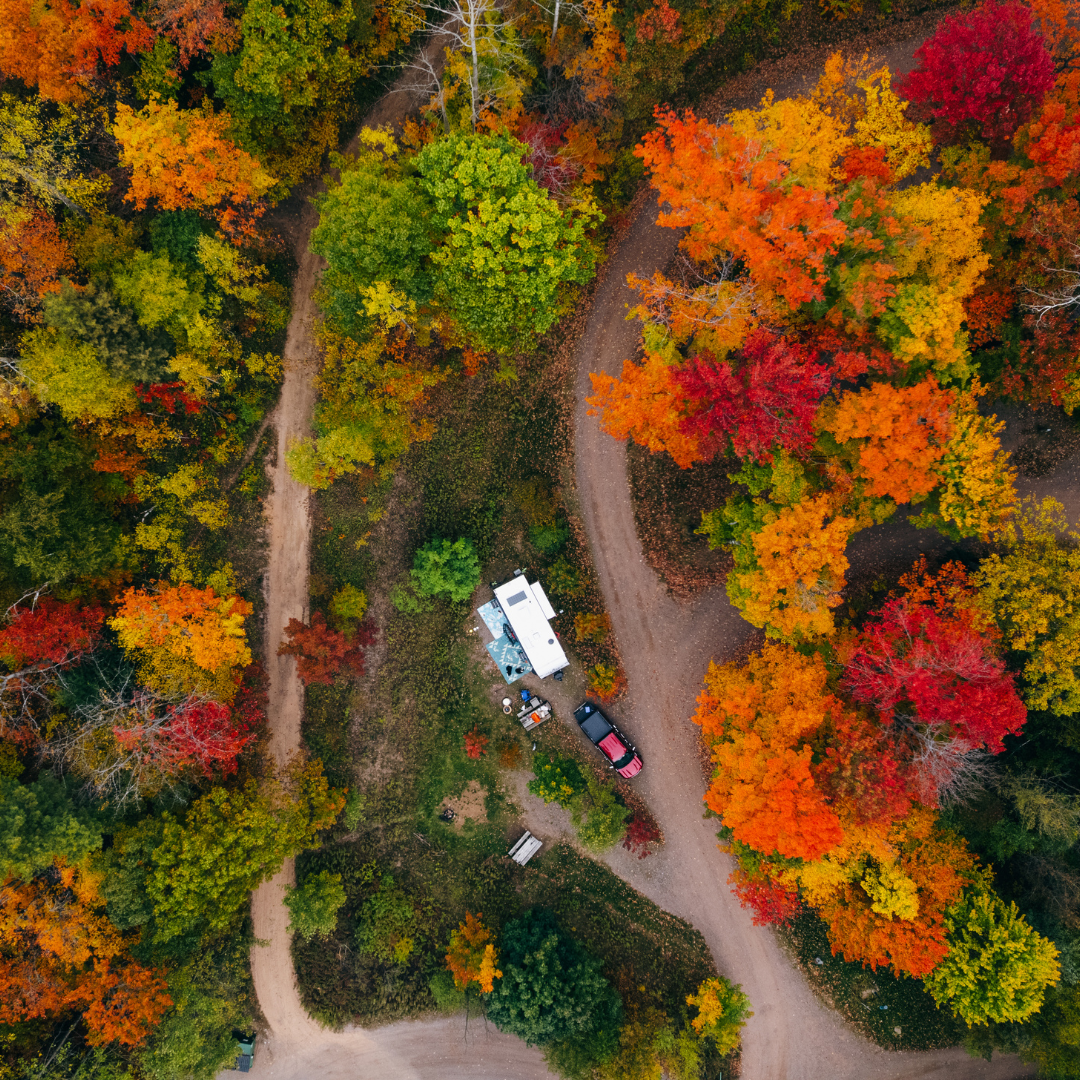 Aerial view of a campground surrounded by vibrant autumn foliage at Raging River Resort in Marquette, Michigan, showcasing the beautiful fall colors of Michigan’s Upper Peninsula.