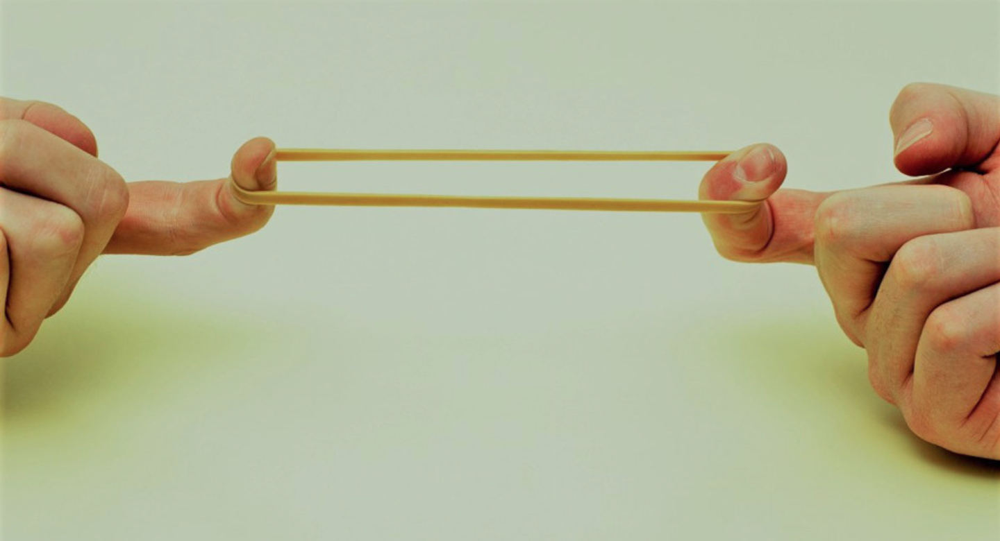 rubber band stretched under tension demonstrating muscle tightness concept