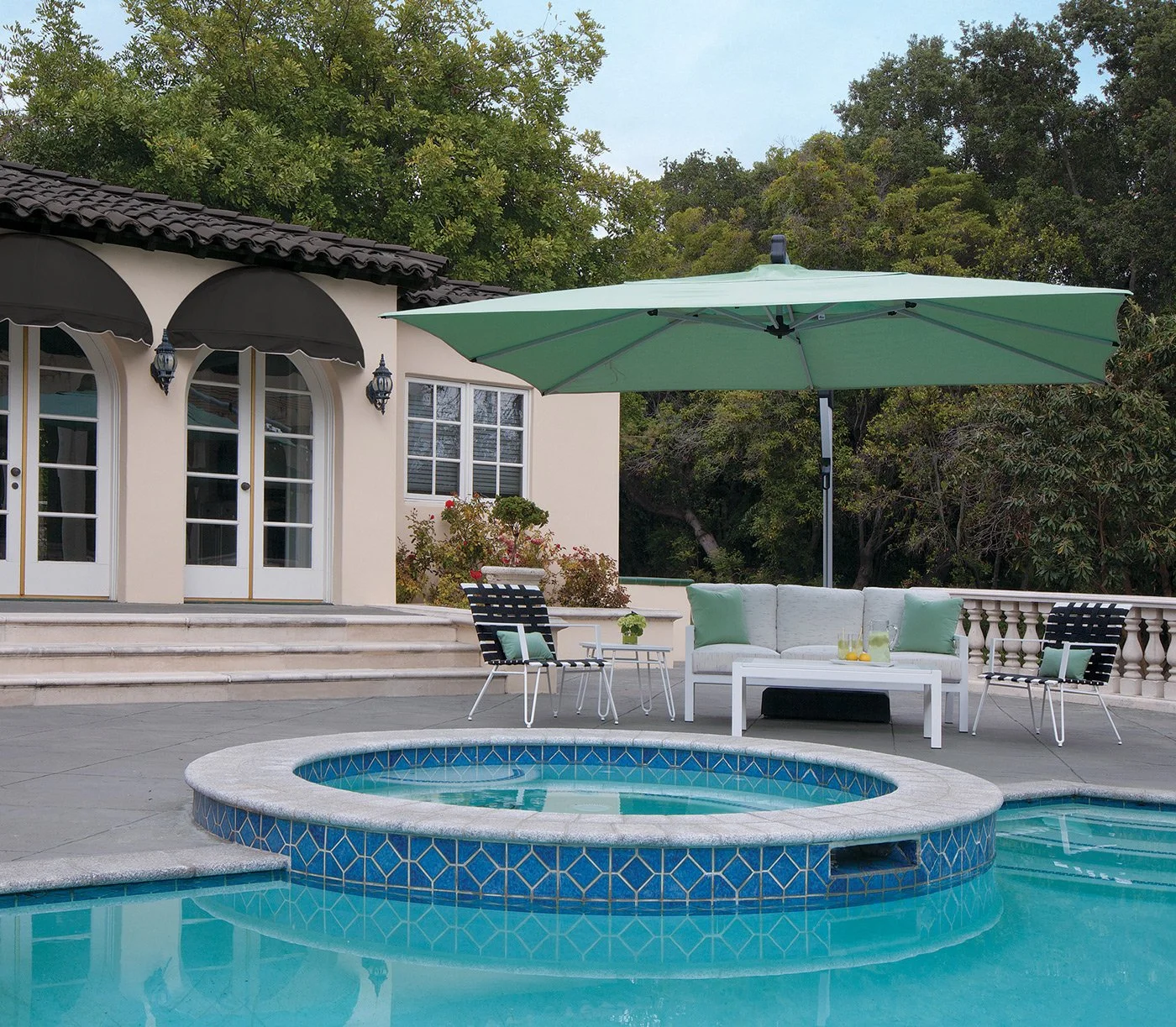 Outdoor patio with pool, seating area, and large umbrella