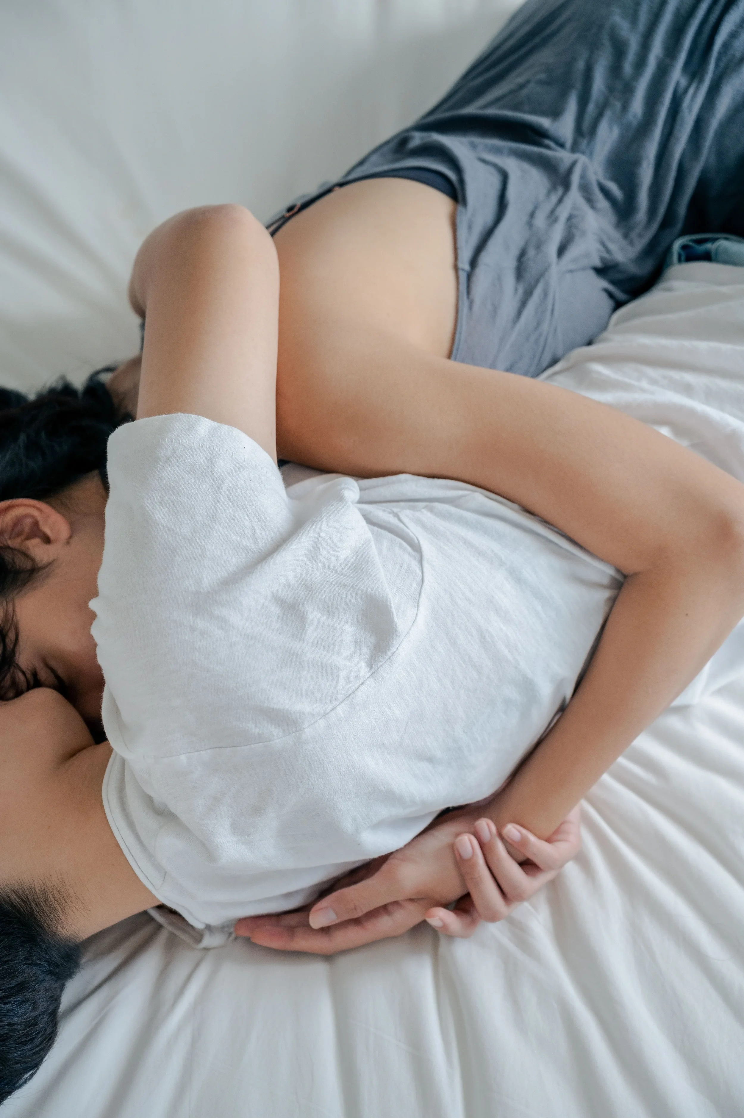 Couple reconnecting after their therapy session on top of a bed cuddling