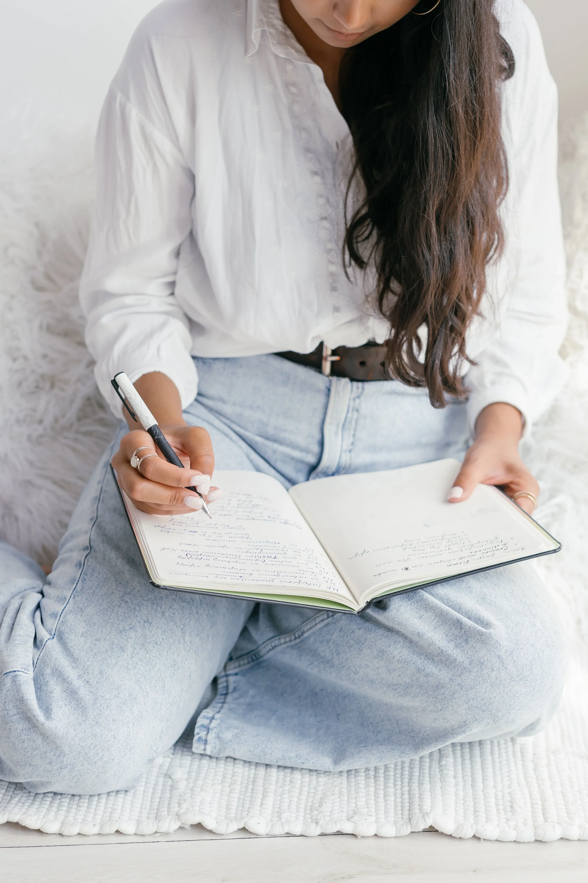 Someone writing in a notebook engaging in self reflection