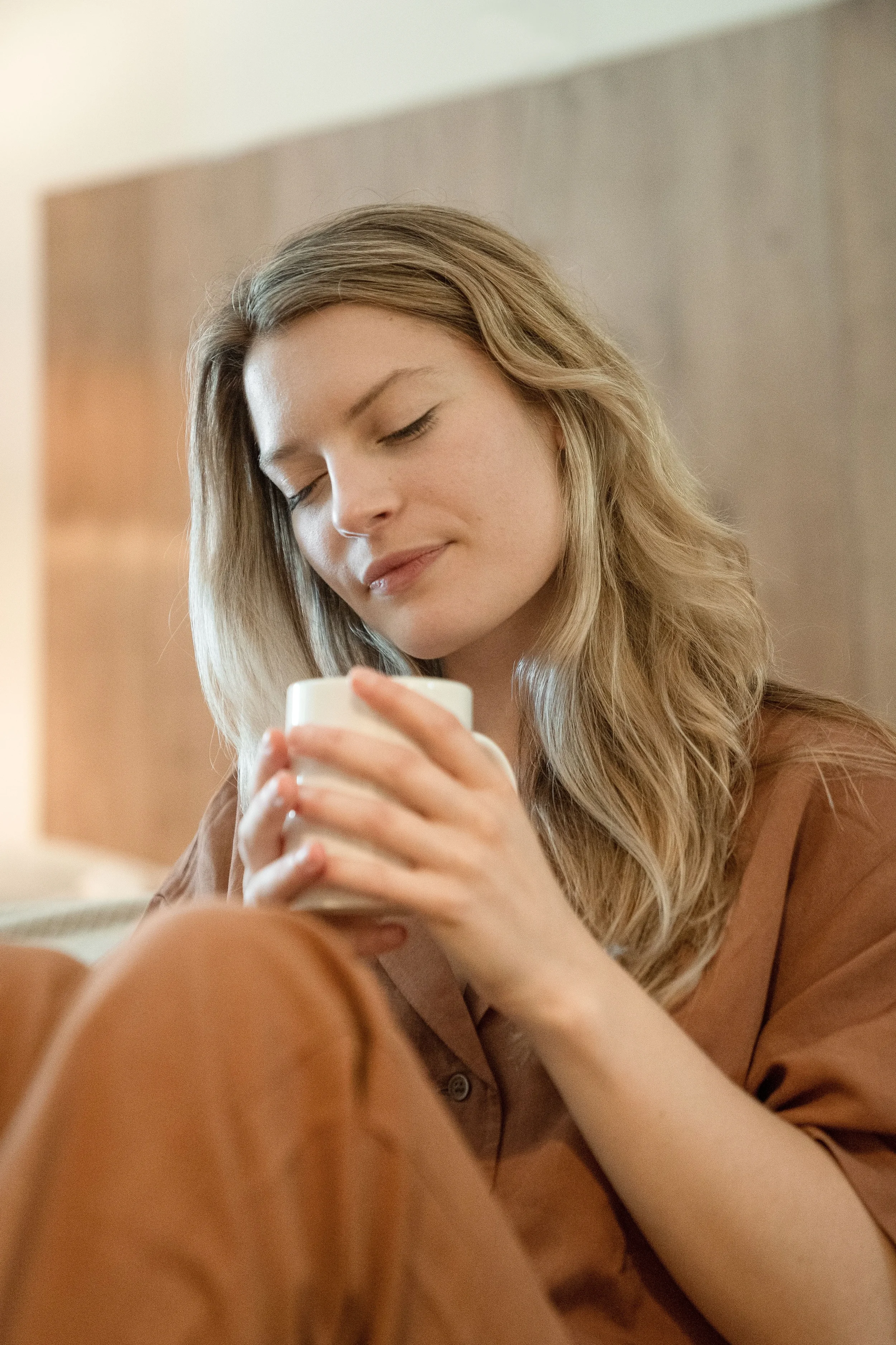 Women at home practicing mindfulness while smelling her coffee