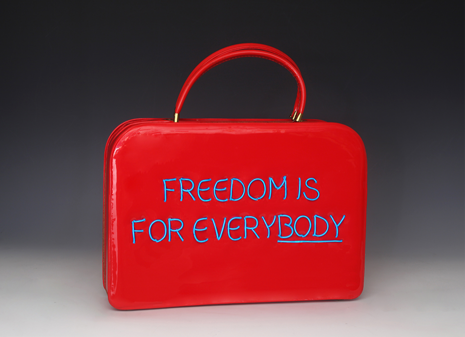 Freedom is for Everybody features a red purse with the phrase “FREEDOM IS FOR EVERYBODY” written in blue, connecting political resistance with women’s economic power.