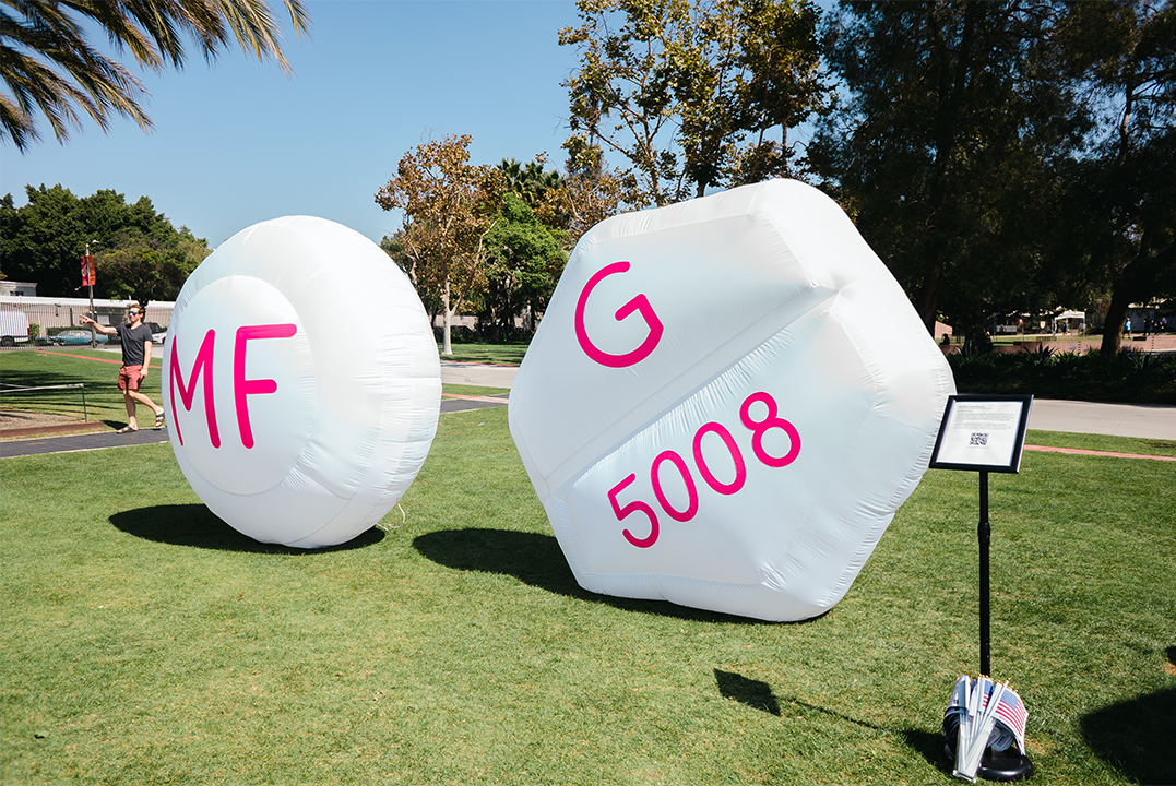 Abortion is Healthcare features a white inflatable sphere marked with pink letters “MF,” representing mifepristone. The work draws attention to abortion access and the importance of medication abortion.