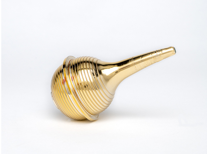 A nose sucker is coated in reflective gold chrome. A round, ribbed bulb connects to a long, narrow nozzle.