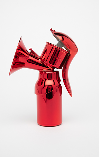 A manual breast pump is coated in reflective red chrome. A curved handle descends on the right for squeezing, while a funnel-shaped opening extends from the left.
