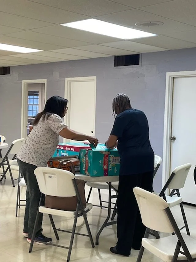 Stanley Community Church's Women of Faith Volunteers helping wrap diapers, they also donated diapers.