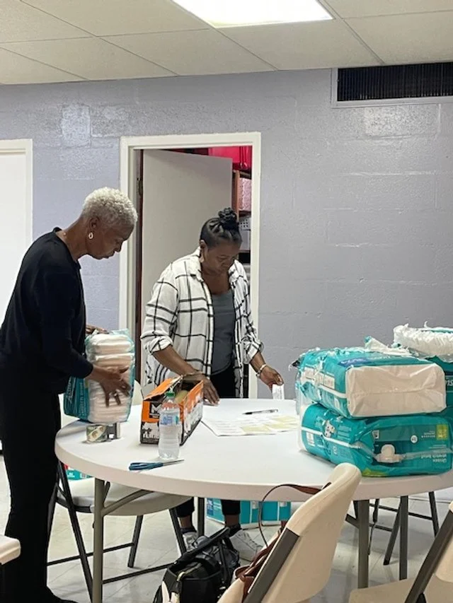 Stanley Community Church's Women of Faith Volunteers helping wrap diapers, they also donated diapers.