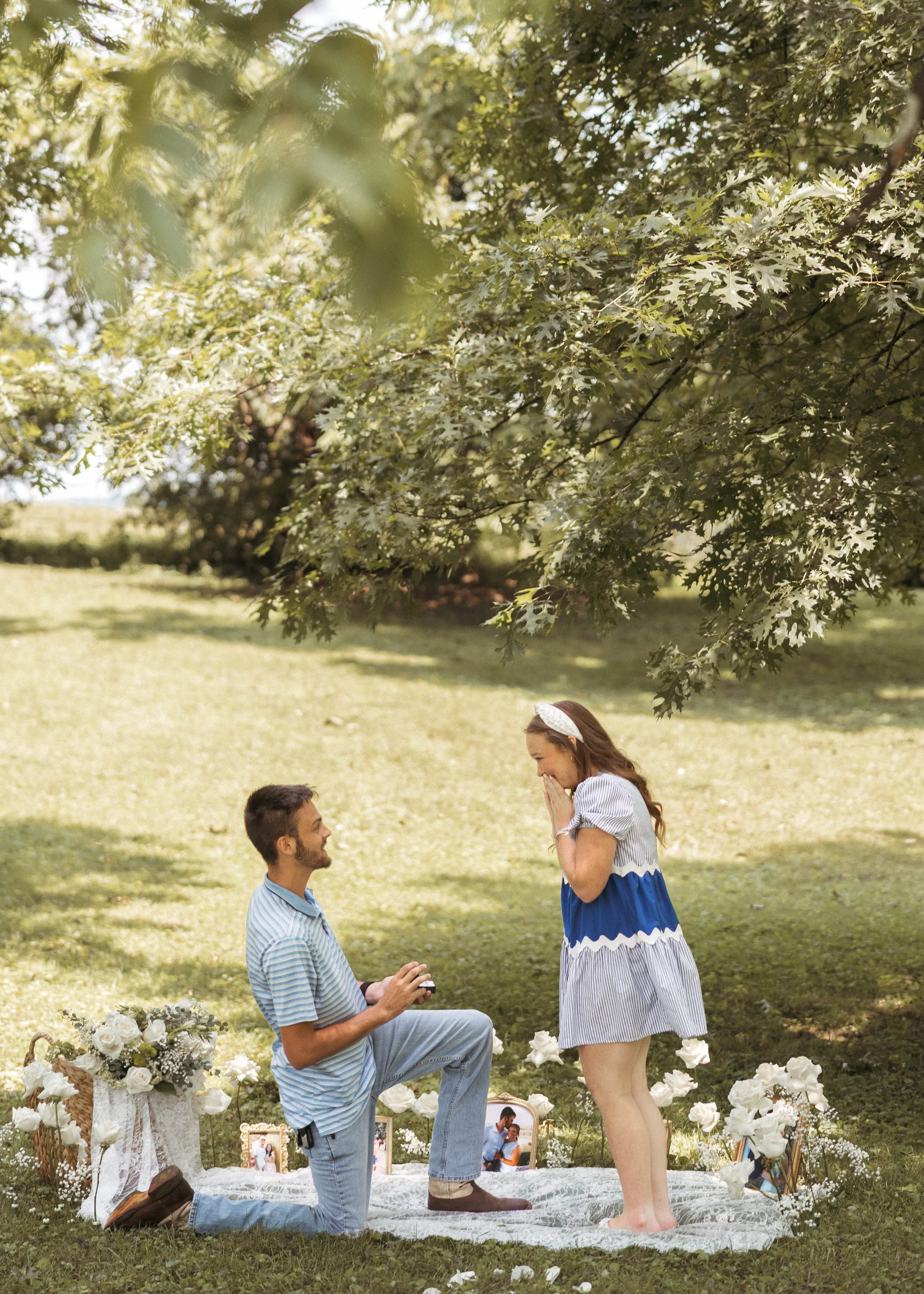 Man getting down on one knee to propose to his girlfriend outside on a sunny summer day in Kentucky.