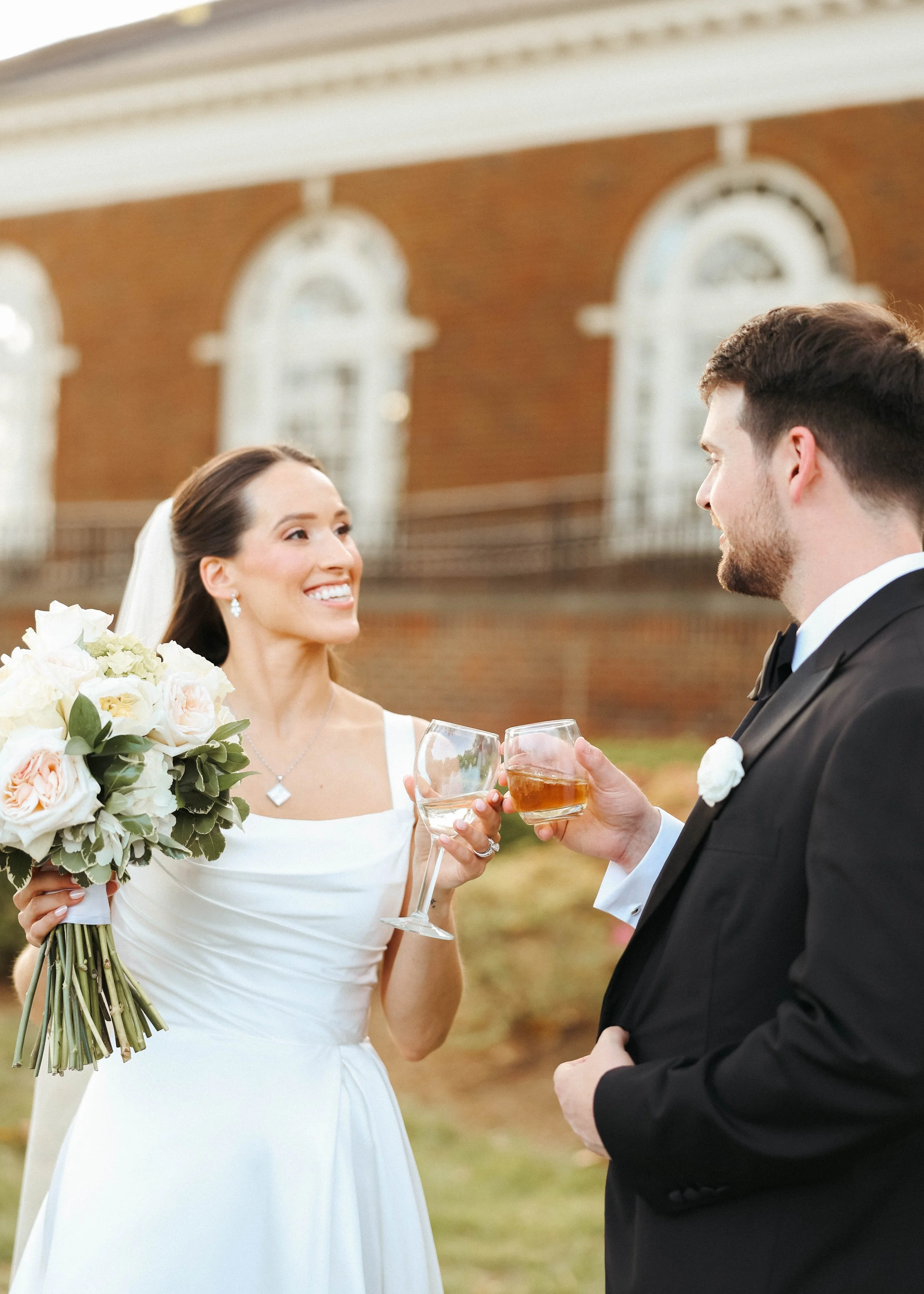 Bride and groom taking their couple's portraits after their Kentucky wedding underneath the bride's veil.