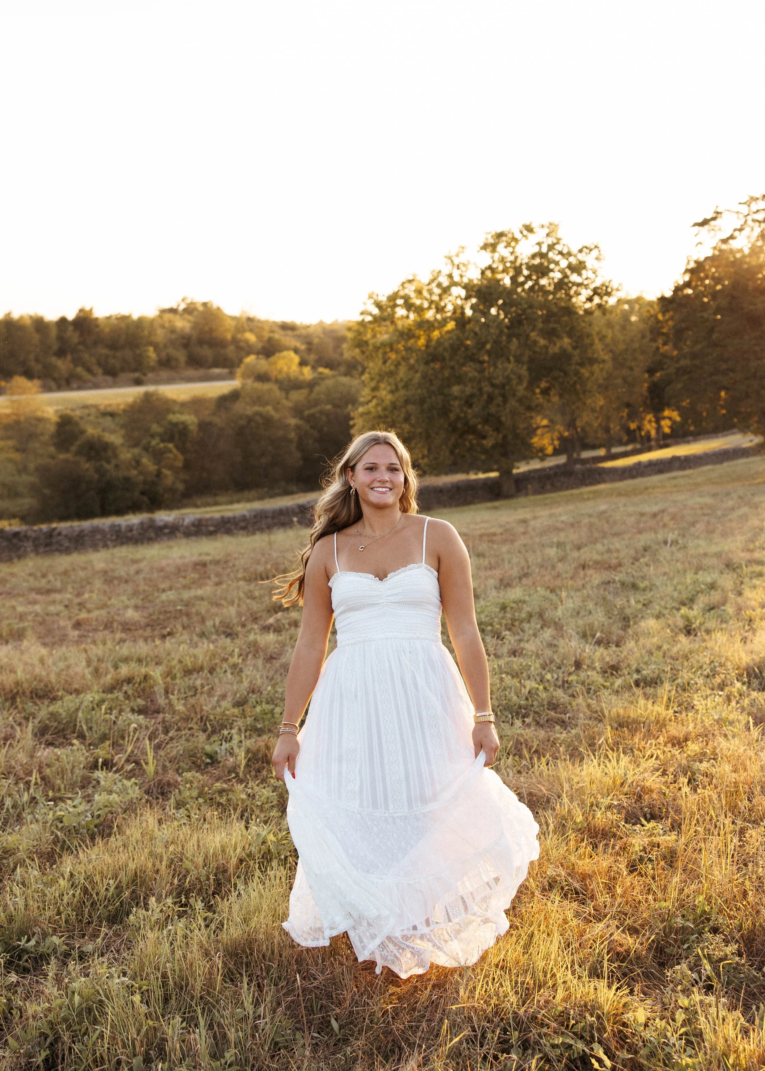 Senior girl running in a Kentucky field at golden hour taking her senior photos