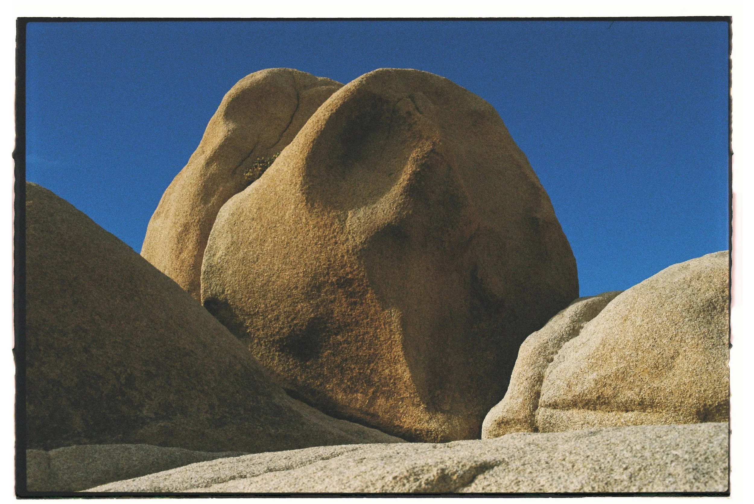 Large weathered granite rocks against a blue sky.