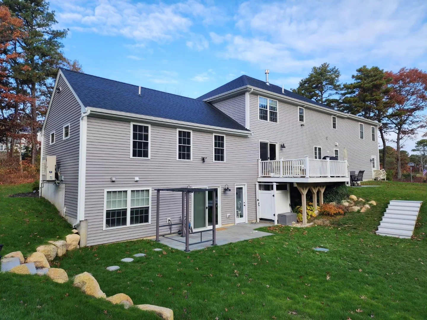 Plymouth house with a large addition, patio doors, and outdoor stairs