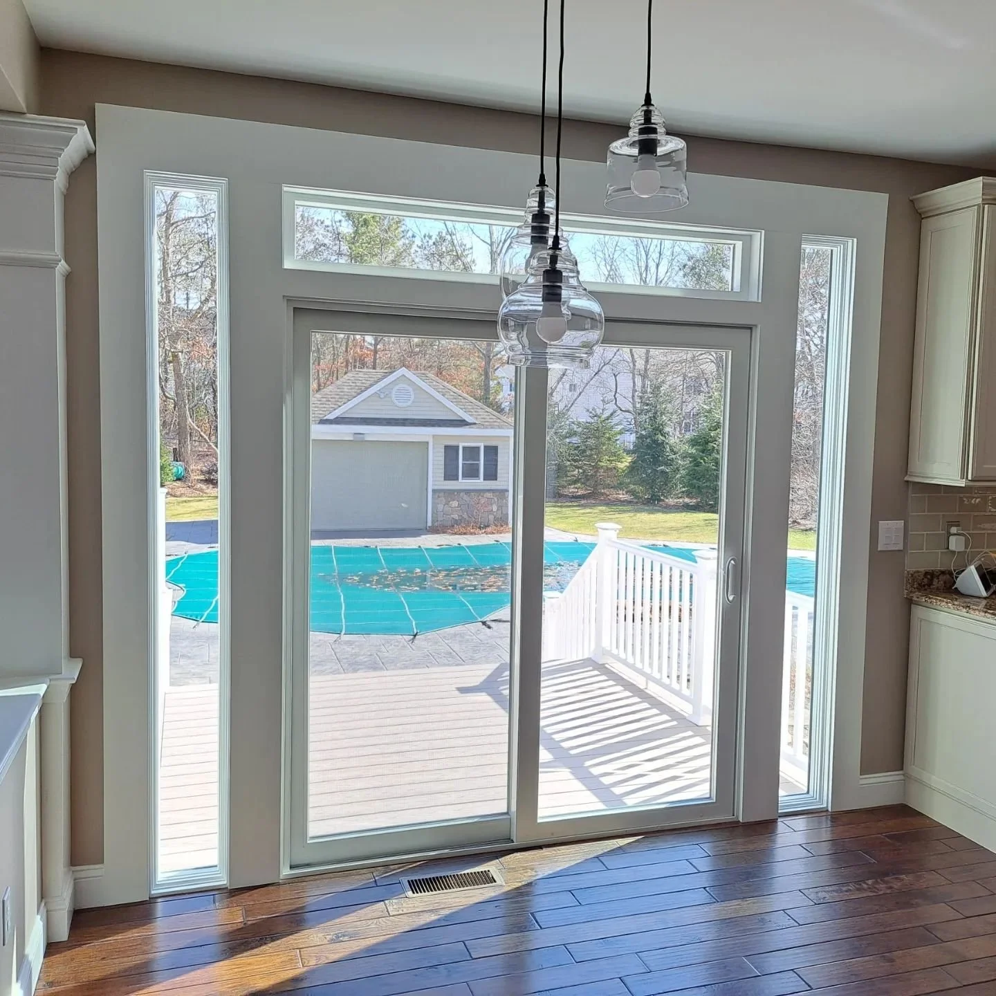 Patio door with sidelights and a transom opening onto a backyard deck