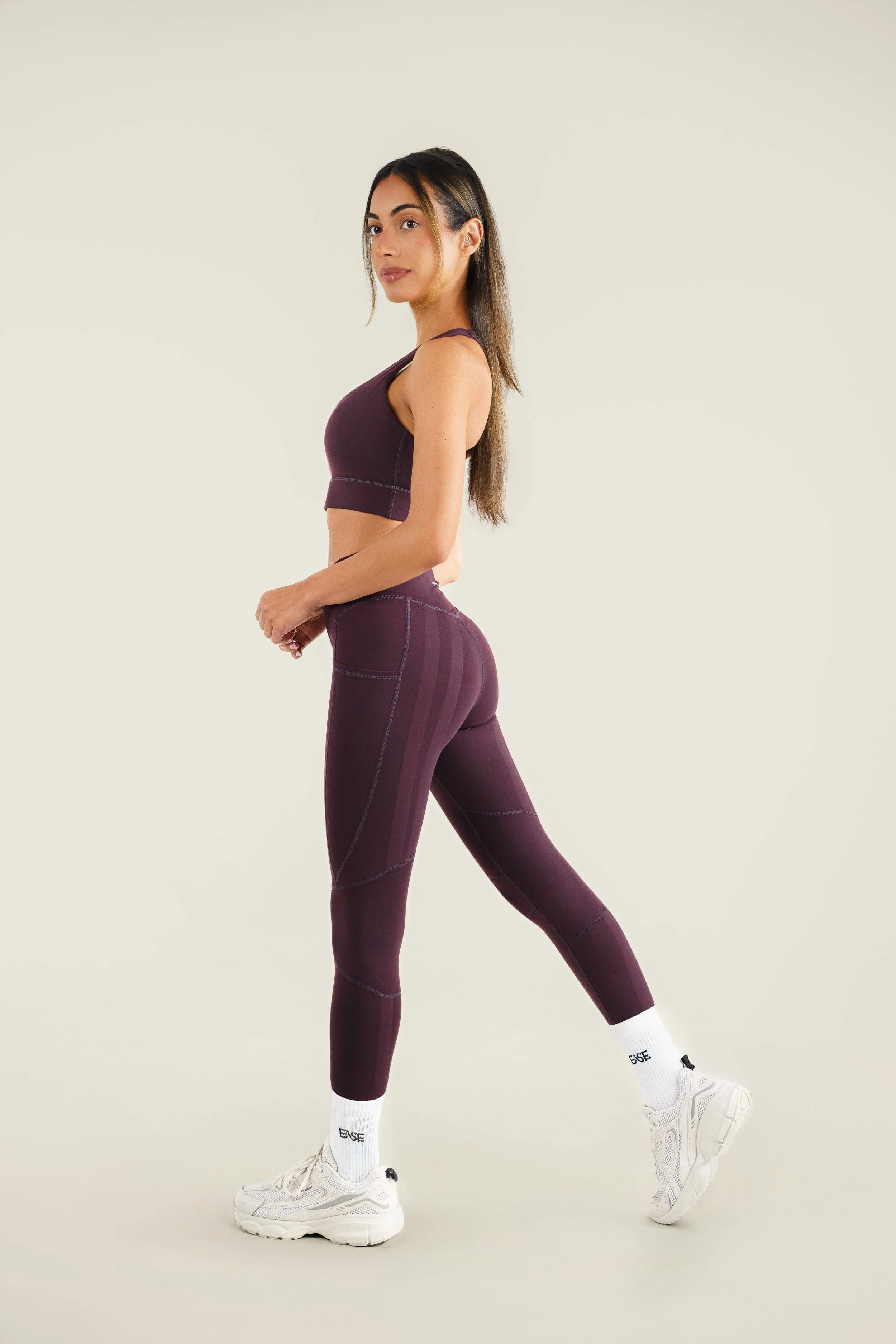 Women in athletic wear stretching against a plain background