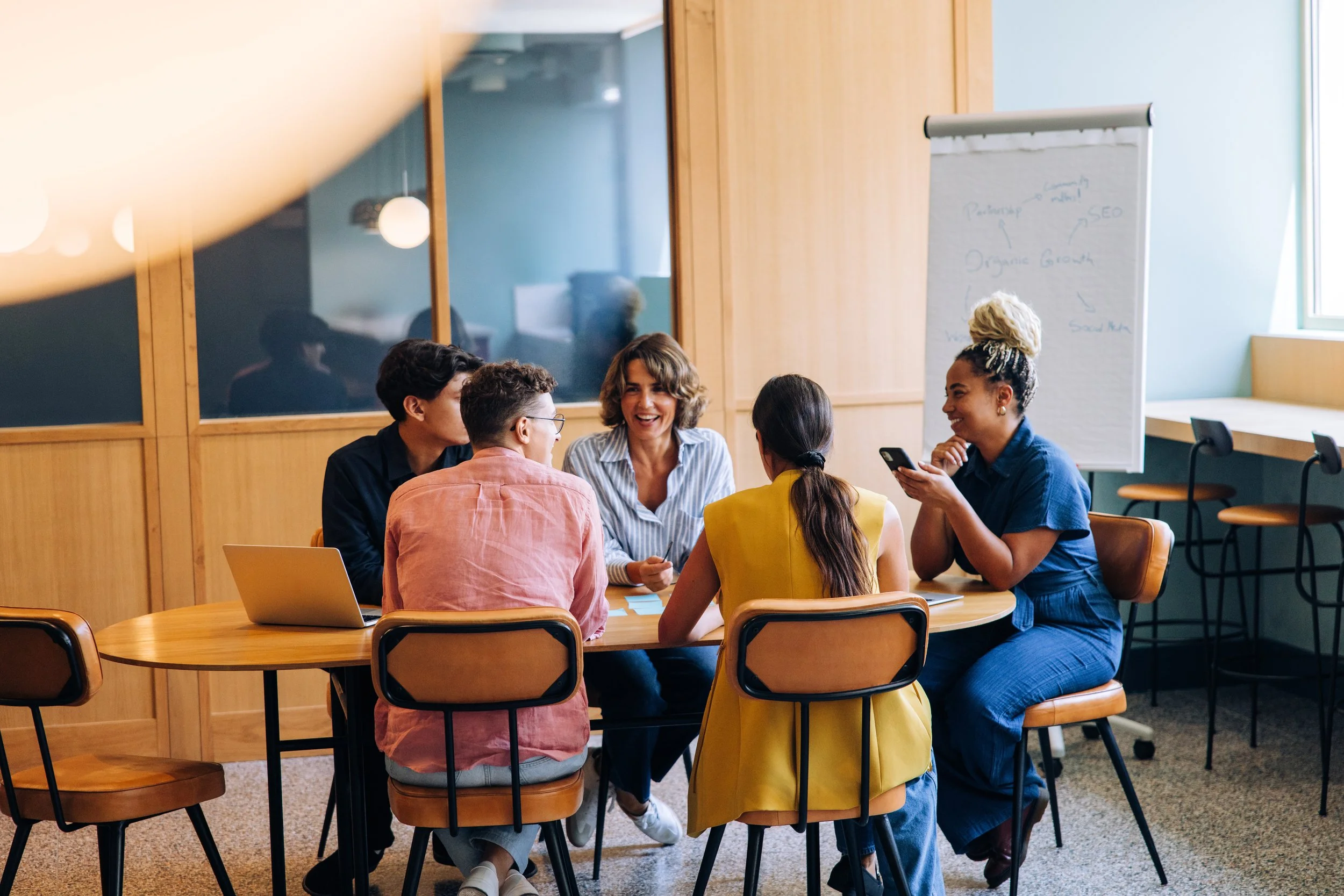Team of colleagues collaborating around a table during a brainstorming meeting in a modern office