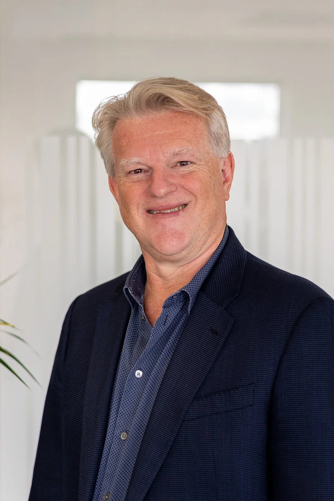 Peter Cluff in dark blue shirt and dark suit smiling