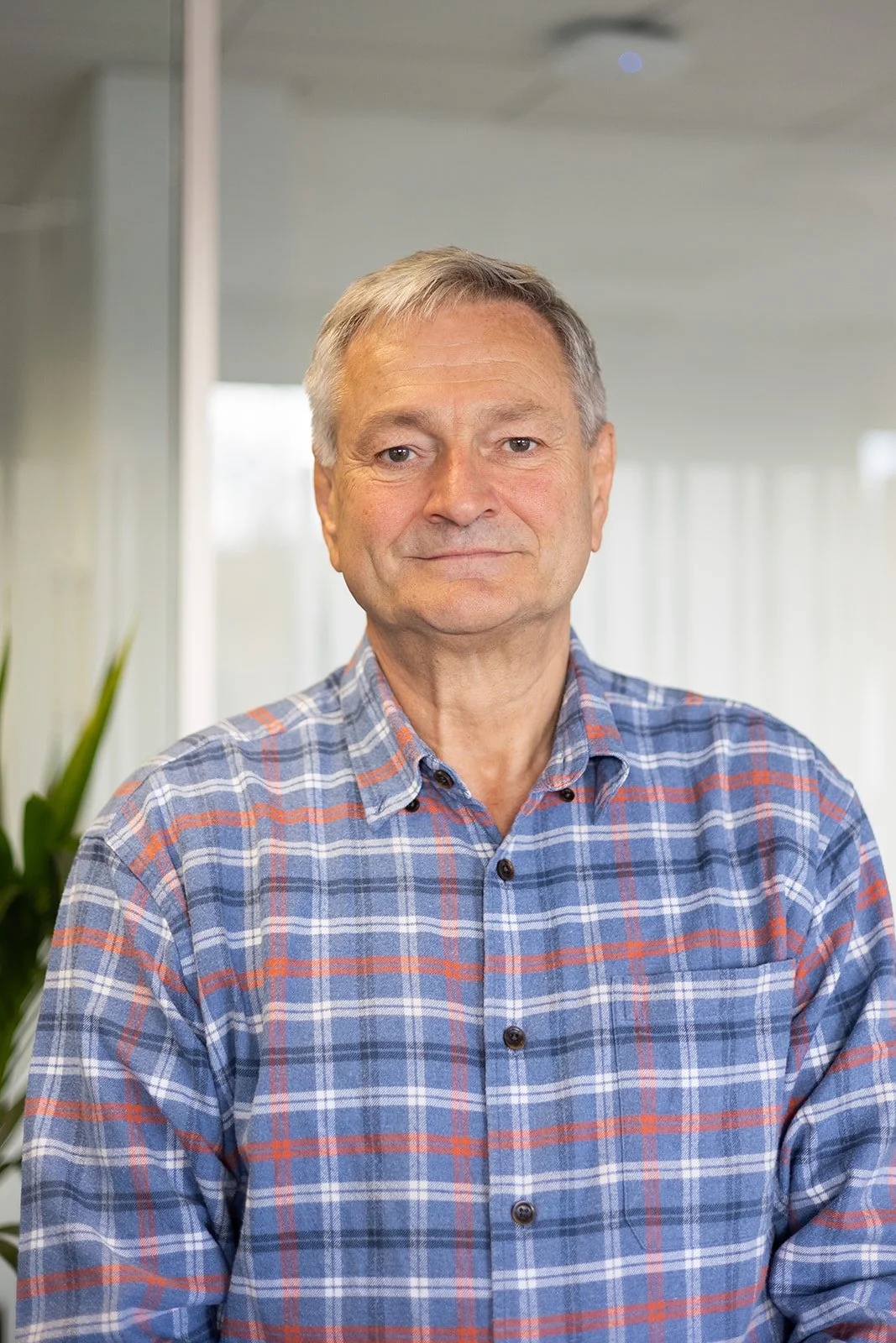 Paul Downes in a checked shirt in a light office