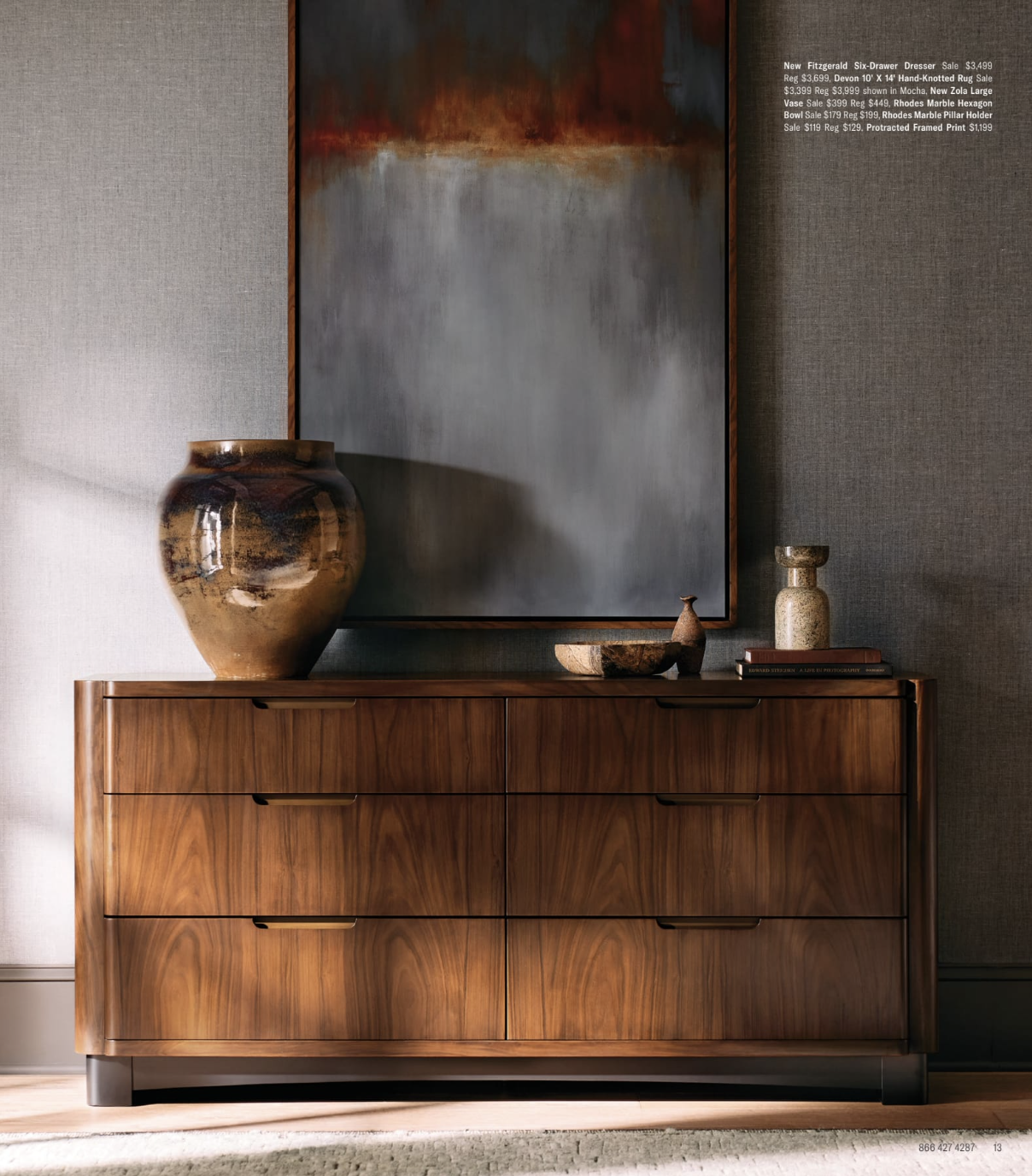 Arhuas 2024 Fall Catalog -- photo shows a large buffet/sideboard with a vase atop it. the warmth of the wood coexists well with the coolness of the grey paint on the walls. a large piece of art hangs above the sideboard, its colors matching perfectly