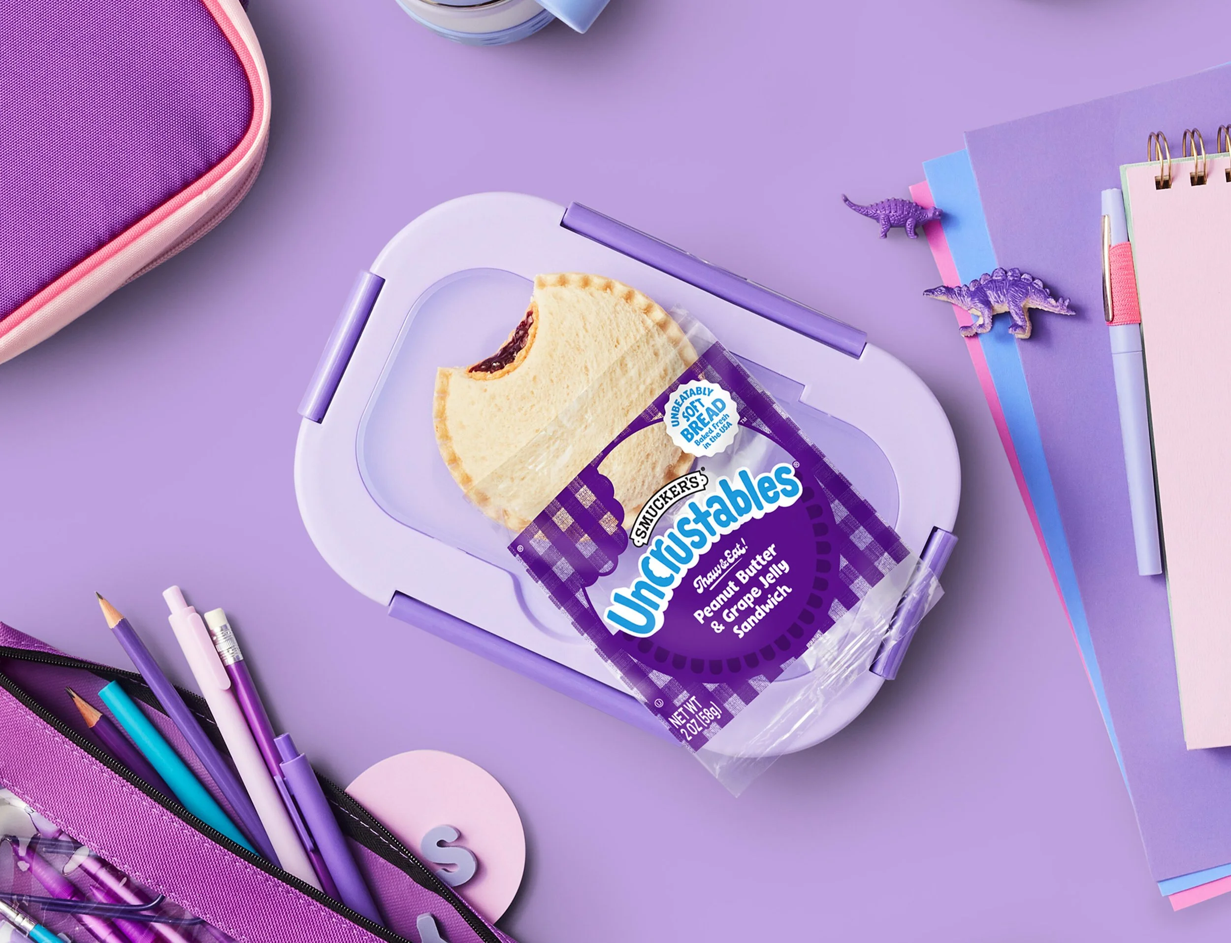 photo shows a grape jelly sandwich sitting atop a purple background with matching purple pencils and toys.