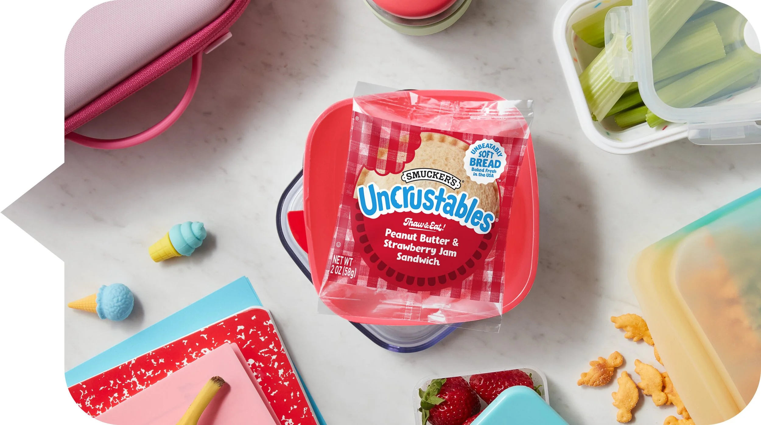 photo shows a strawberry uncrustable sitting on a counter near other snacks and toys.