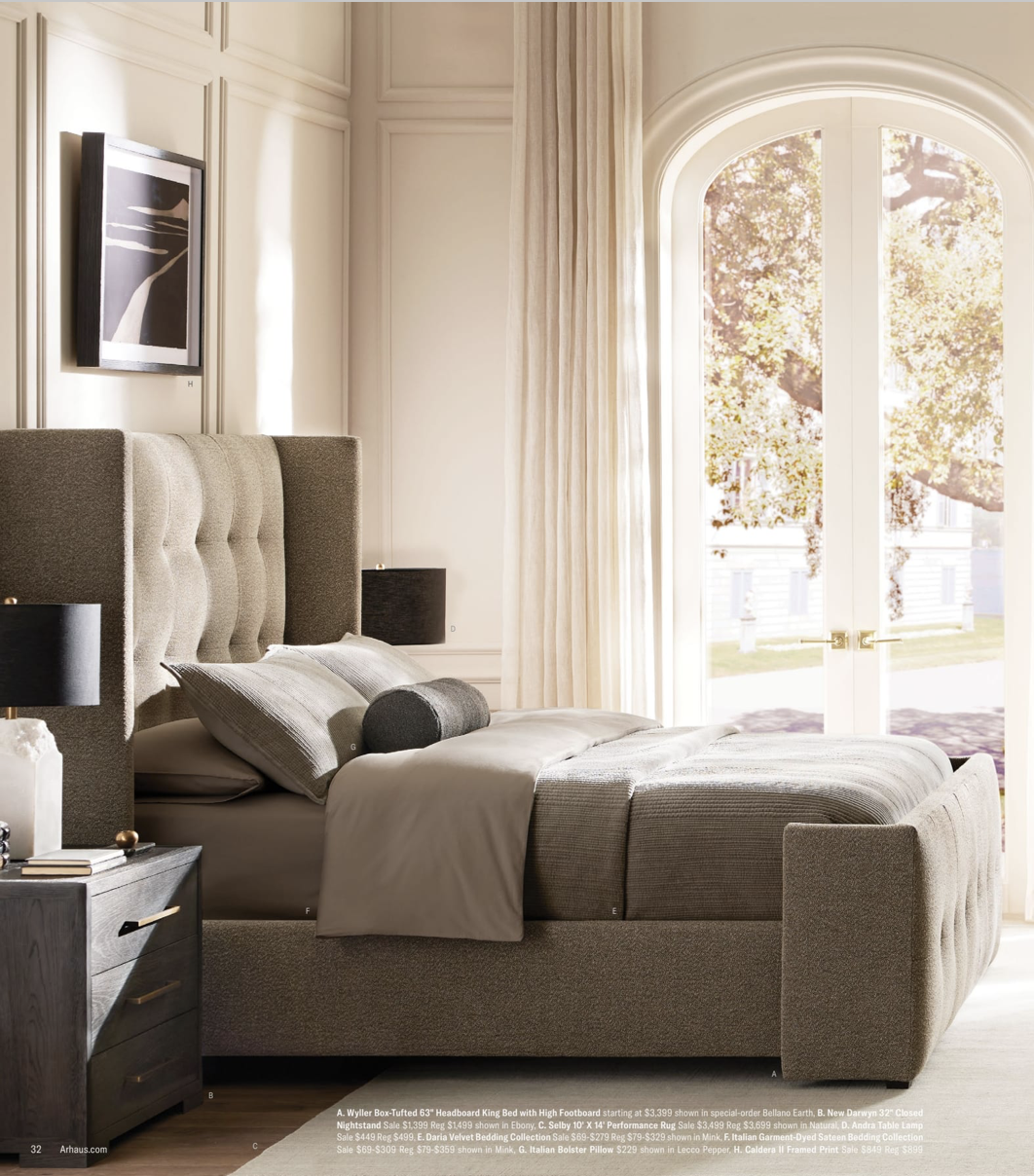 Arhuas 2024 Fall Catalog -- photo shows a large, plush bed from the side. the headboard is tufted, a large arched window allows beautiful white morning light to pour in.