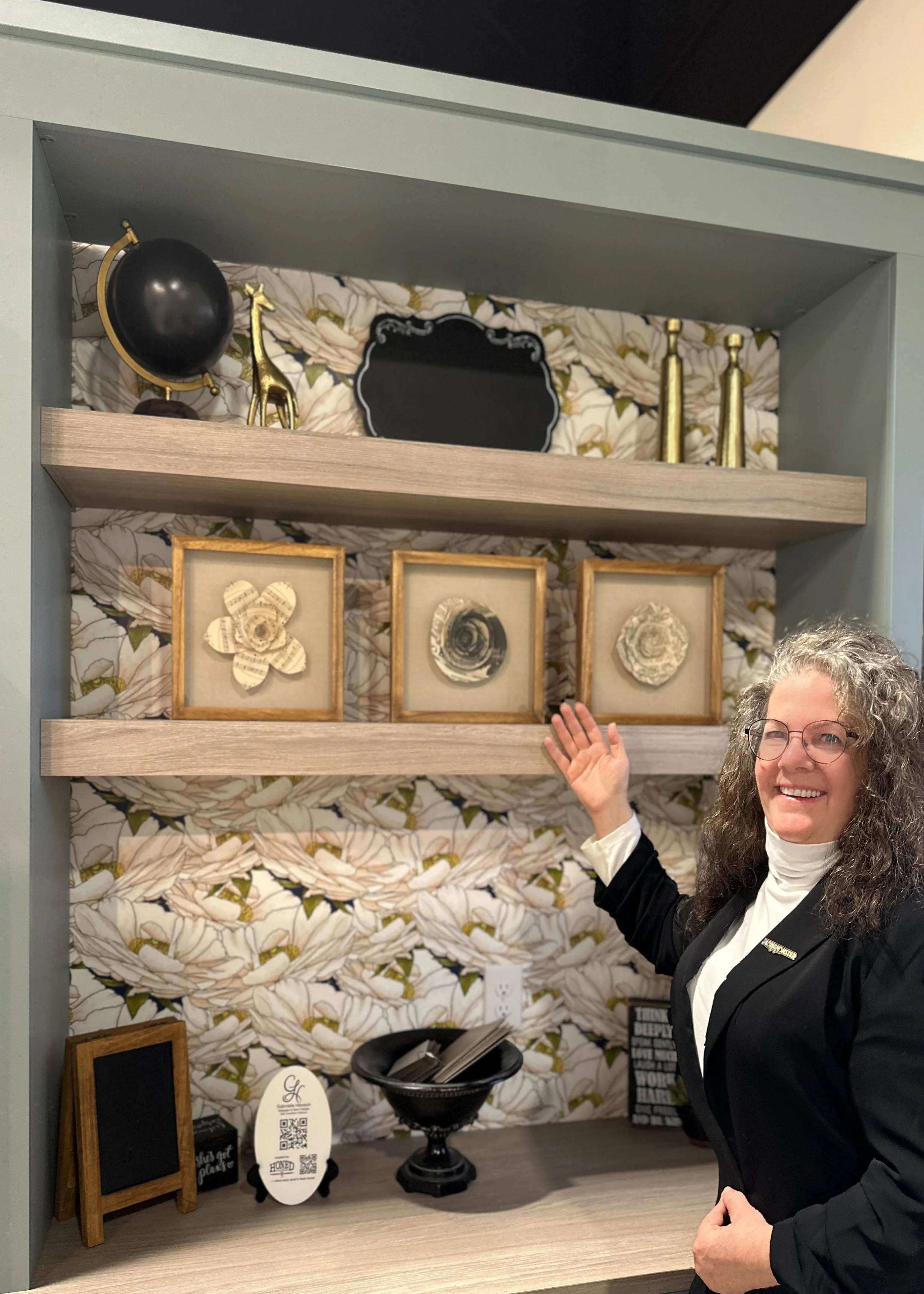 Gabrielle Hewson in front of her Watercolor Florals 05 installed in Concept 32's showroom office cabinetry nook