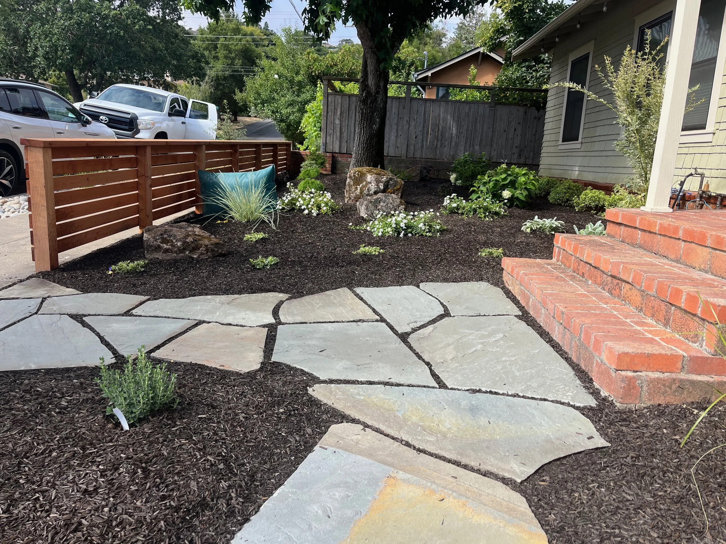 Flagstone walkway joins sidewalk to brick front porch.