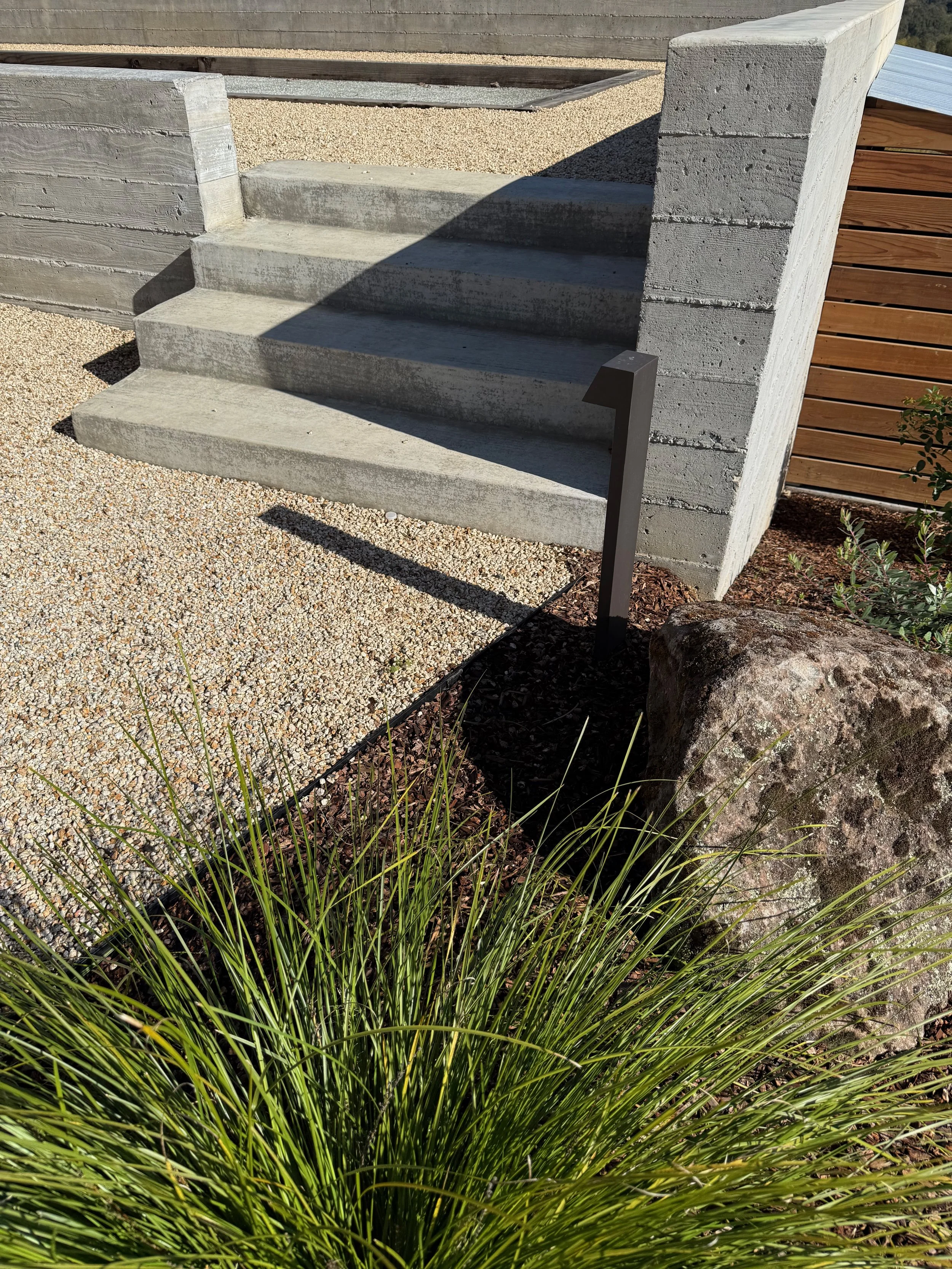 Form-poured concrete retaining wall and Sonoma Gold pathway with sonoma fieldstone boulders.
