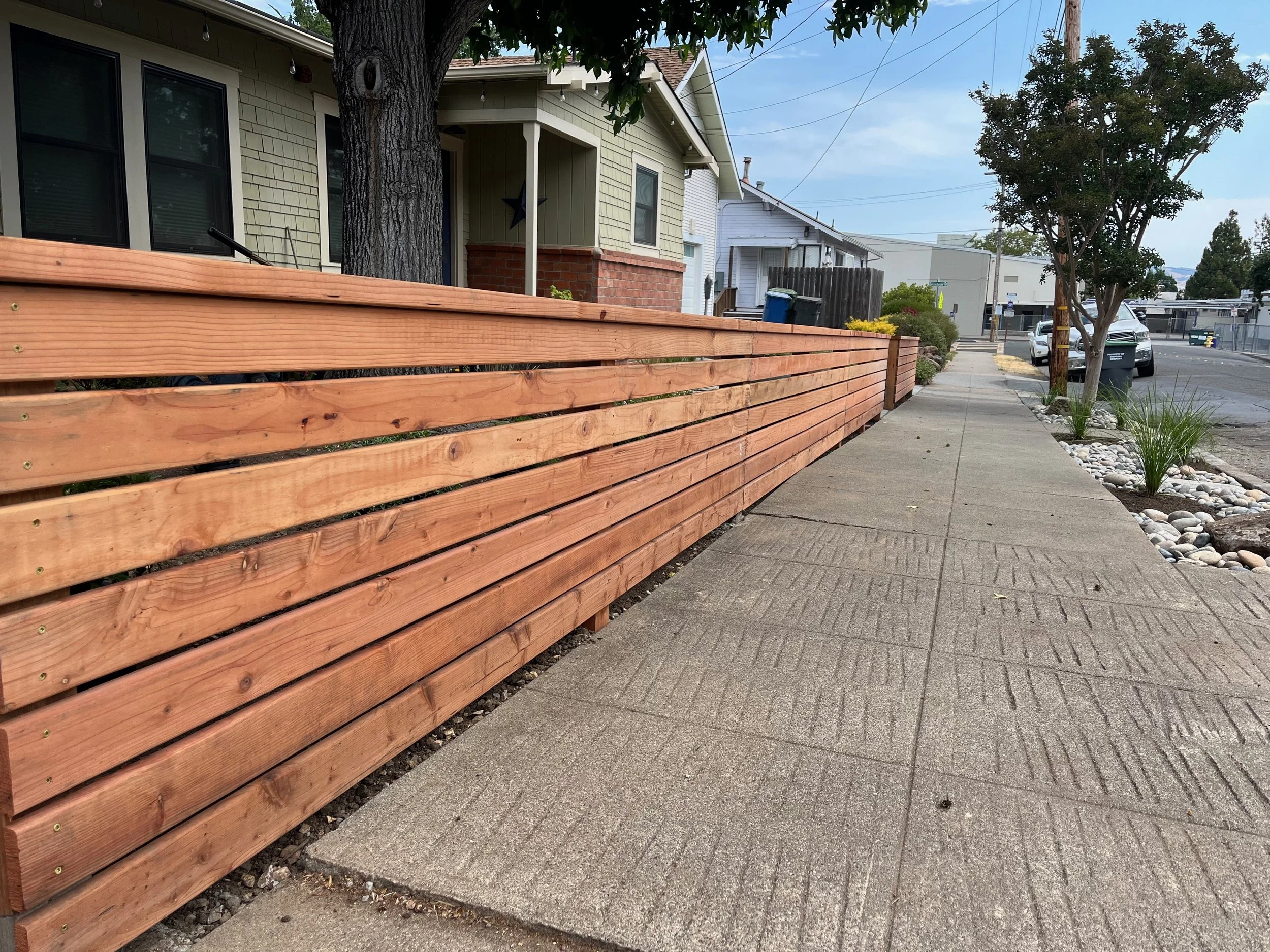 Modern horizontal board fence along sidewalk in West Petaluma, CA.